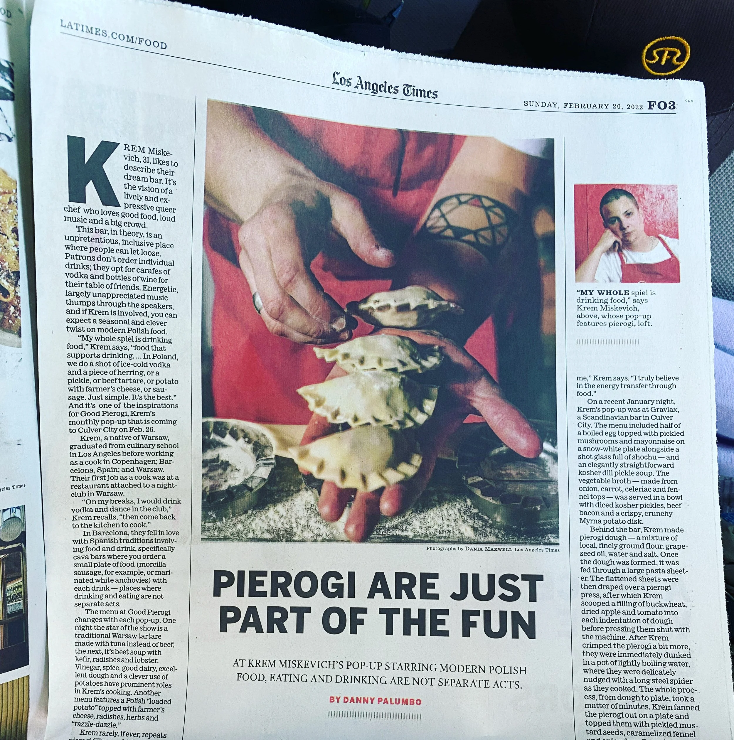 Newspaper article from the Los Angeles Times with the headline "Pierogi are just part of the fun". The main image shows a person with tattoos holding and serving a pierogi, with the caption "Photographs by DANIA MAXWELL Los Angeles Times". The right 