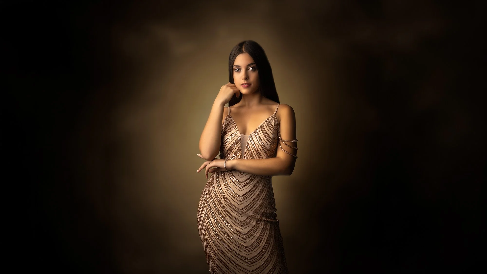 Retrato de una mujer joven con vestido dorado elegante en fondo oscuro.