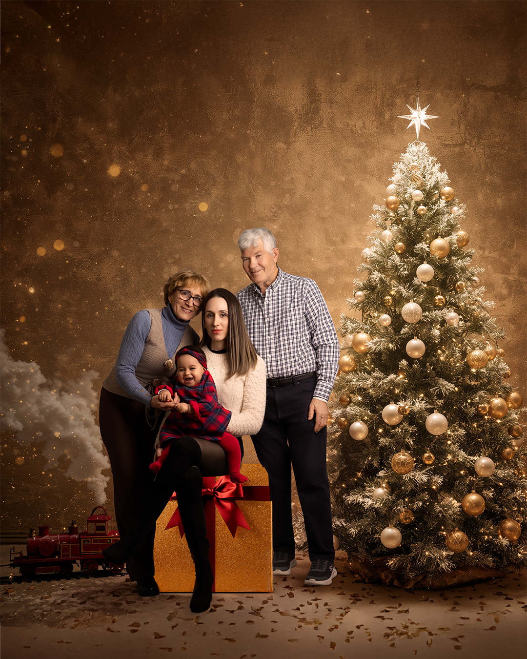 Familia de cuatro personas en Navidad, con árbol decorado y regalos, en fondo dorado y nieve artificial, en interiores.
