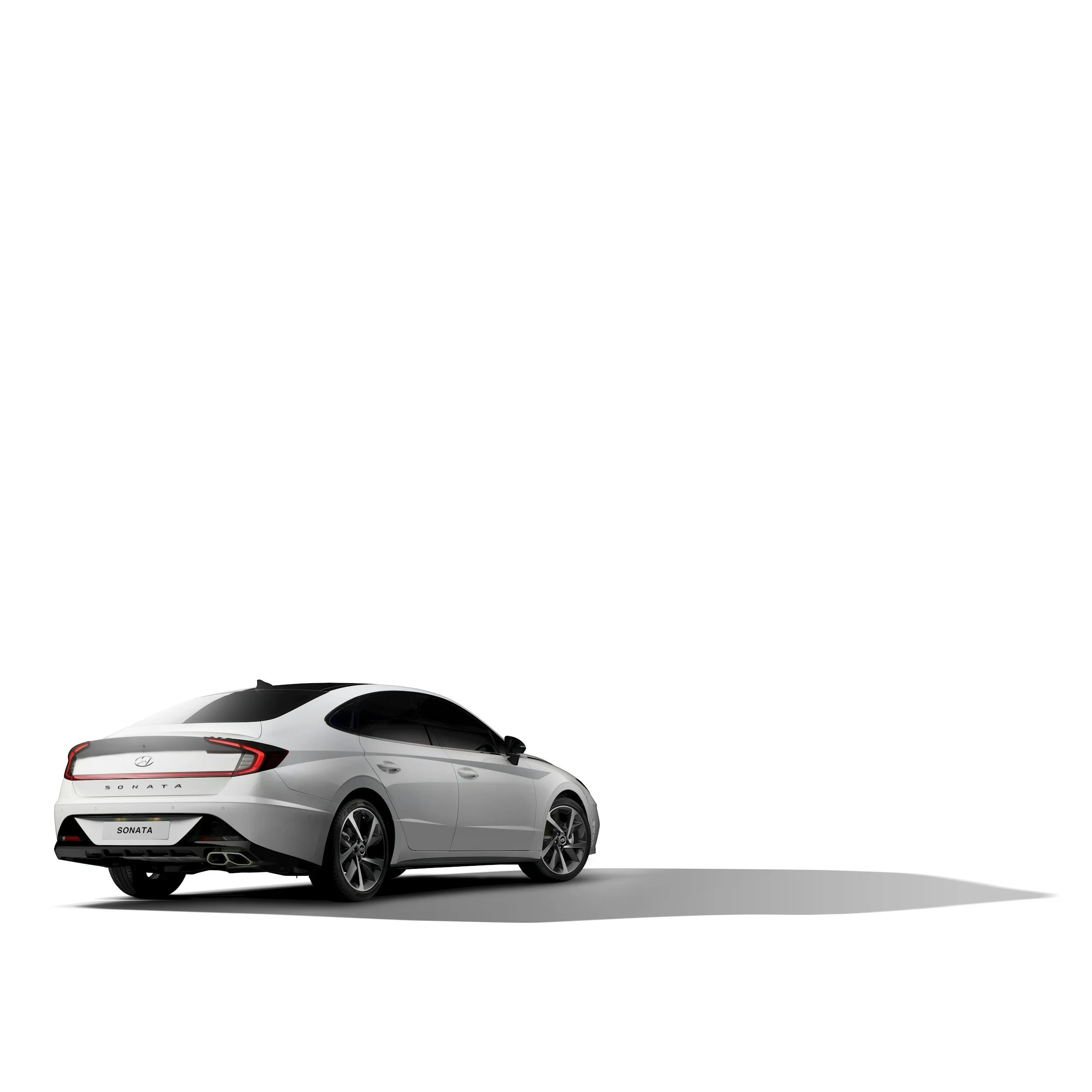 A white Hyundai Sonata sedan car casting a shadow on the ground, viewed from the rear and side.