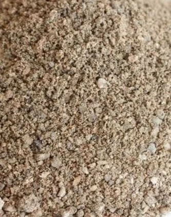 Close-up of a textured, granular sand or dirt surface.