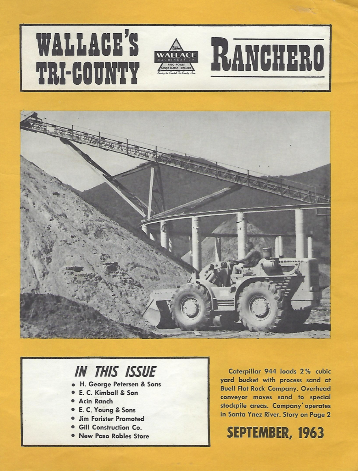 Black and white photograph of a Caterpillar 944 loader moving sand into a bucket at a processing site with an overhead conveyor system in the background.
