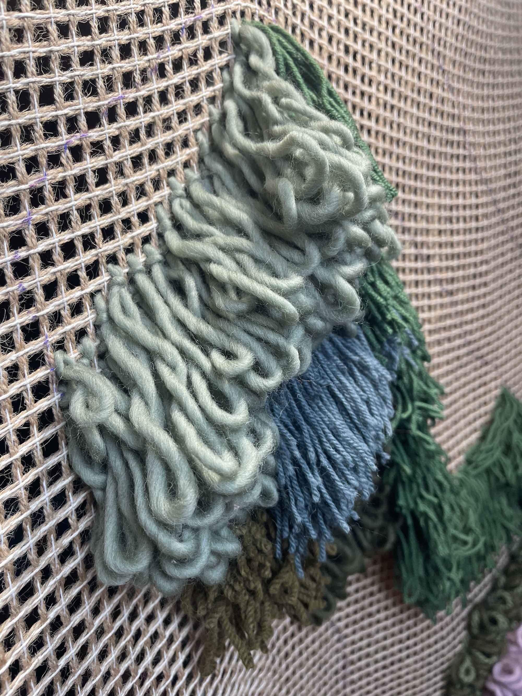 The process of applying organic wool to the tapestry base.