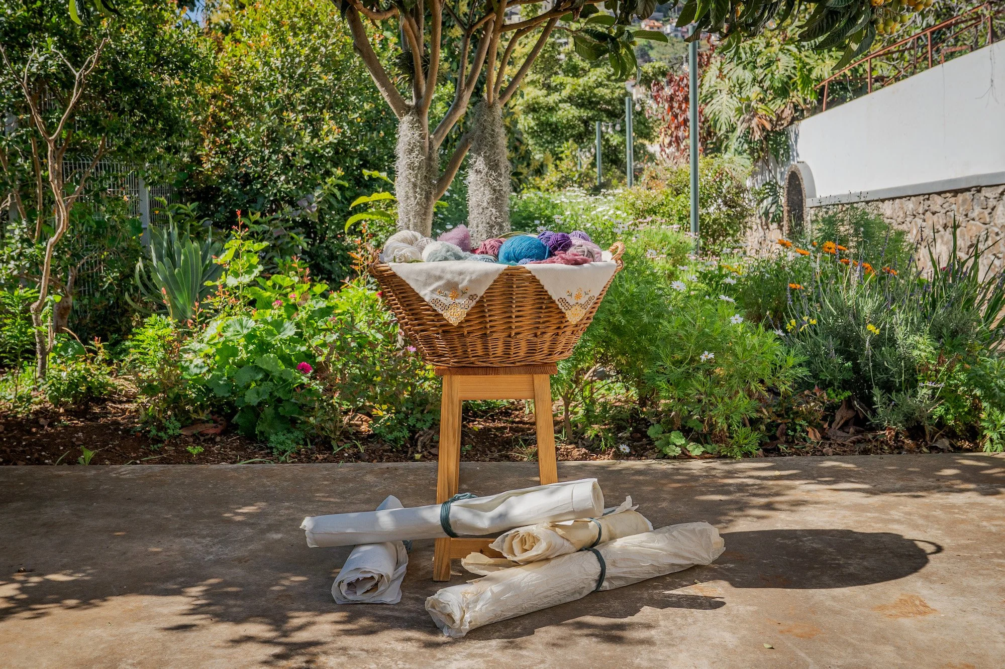 A comprehensive view of the creative process: organic sheep's wool, technical blueprint grid, and Madeira Embroidery.