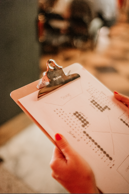 Person holding clipboard with pie charts and bar graphs in a business setting.