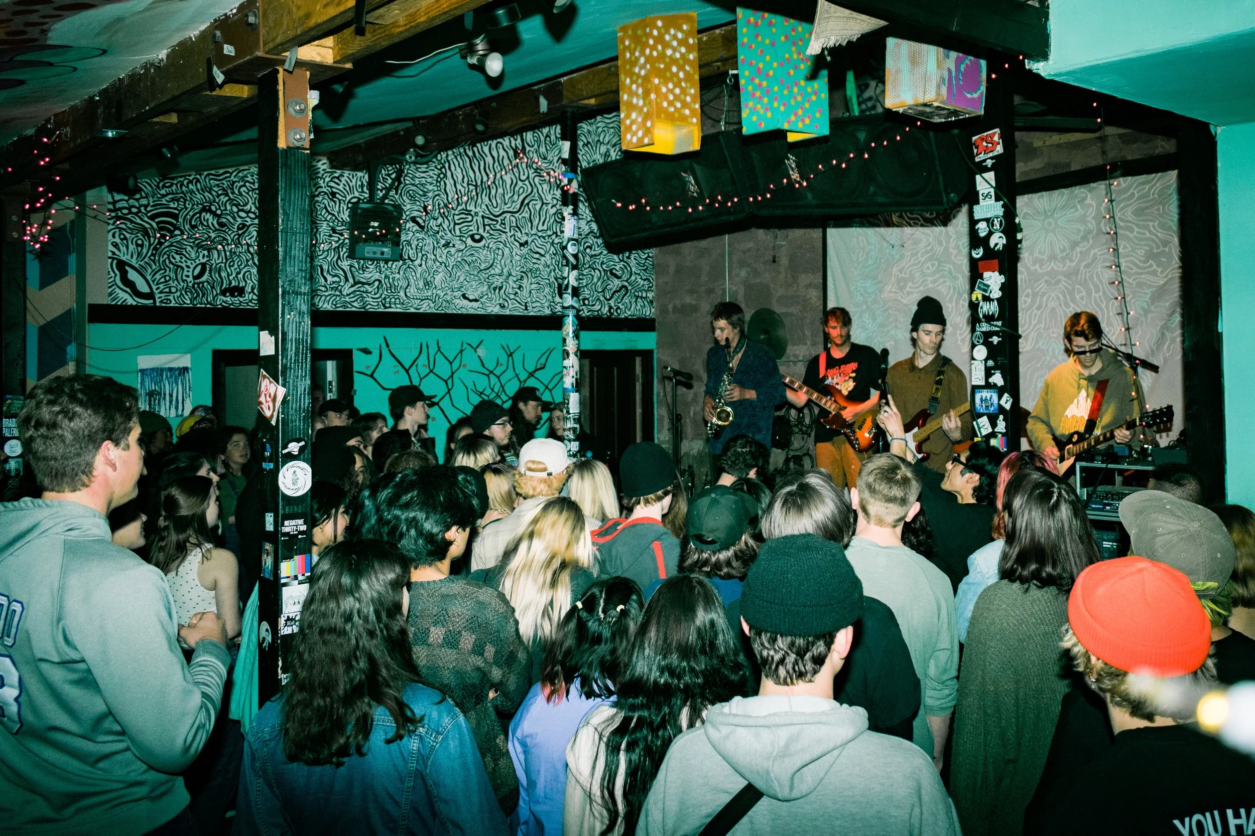 A live music performance at a local venue with a band playing on stage and an audience watching.