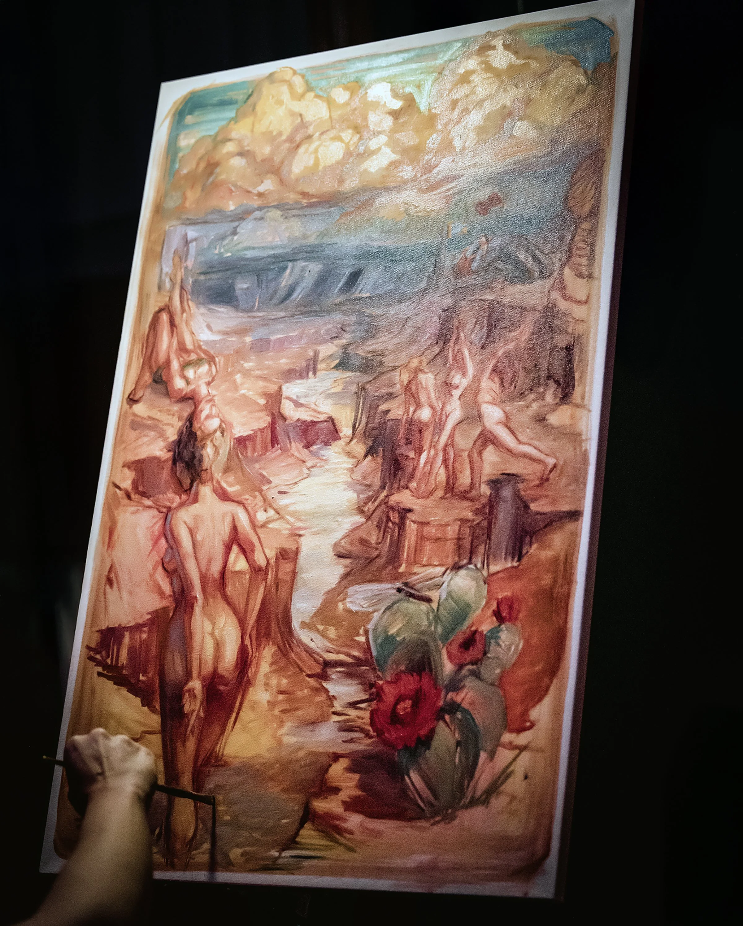 Painting of multiple nude human figures near a body of water, with a landscape of clouds and water in the background, and large red flowers in the foreground.