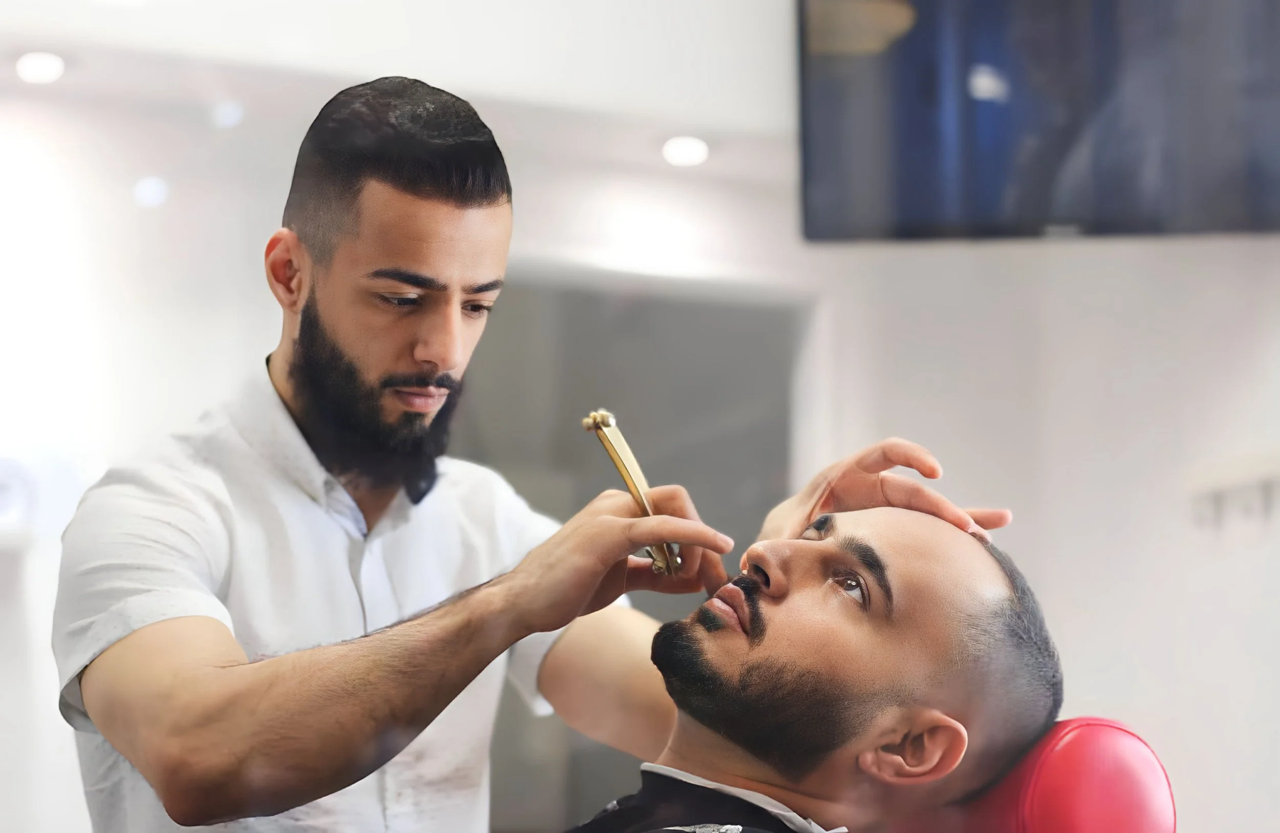 Reza Alavi, founder of Finest Touch performing detailed haircut and beard grooming service.