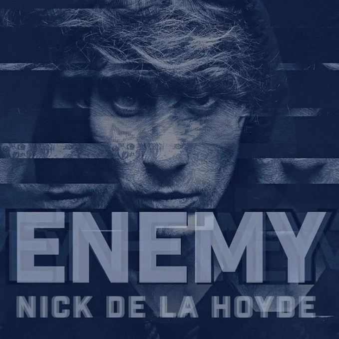 Book cover titled 'Enemy' by Nick de la Hoyde with a monochrome image of a person's face with intense eyes and messy hair.