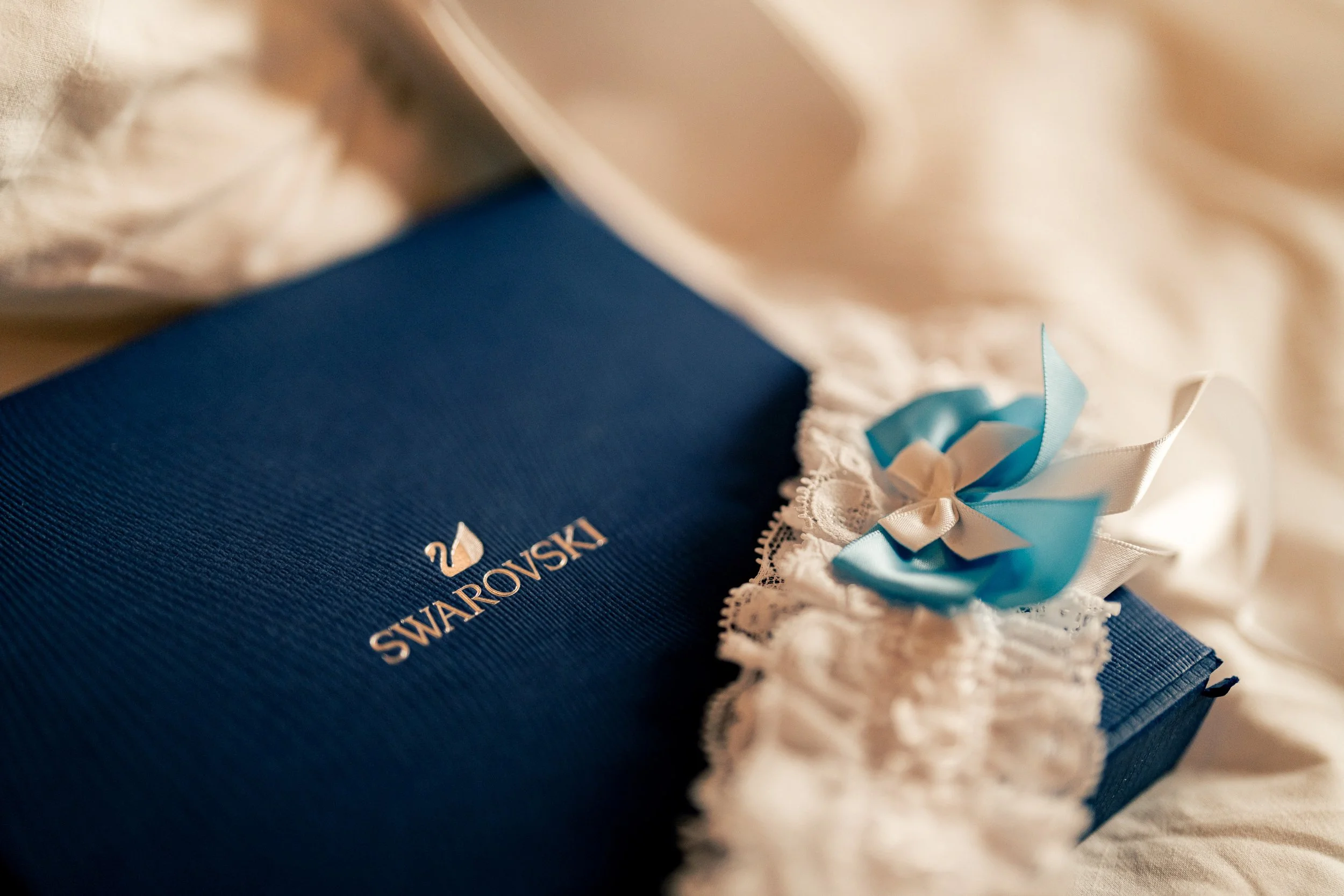 Morsiamen Swarovski-rasia ja pitsinen sukkanauha sinisellä rusetilla Hotel NH Collectionissa Helsingissä. Hääkuvaus Helsinki - Hyvän mielen hääkuvaaja Sami Turunen.
