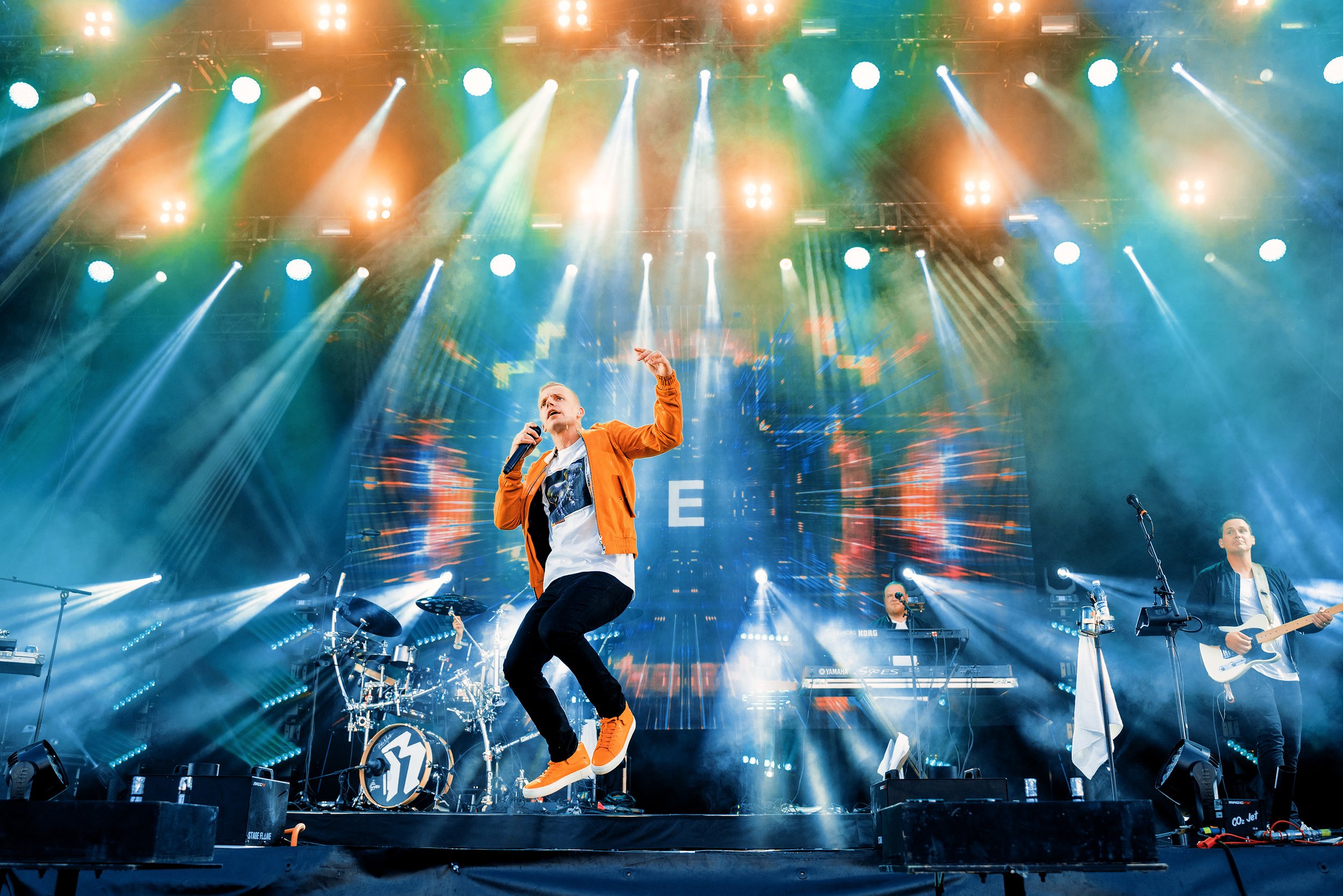 Elastinen pomppaa ilmaan livekeikalla. Musiikki- ja konserttikuvaus – valokuvaaja Sami Turunen.