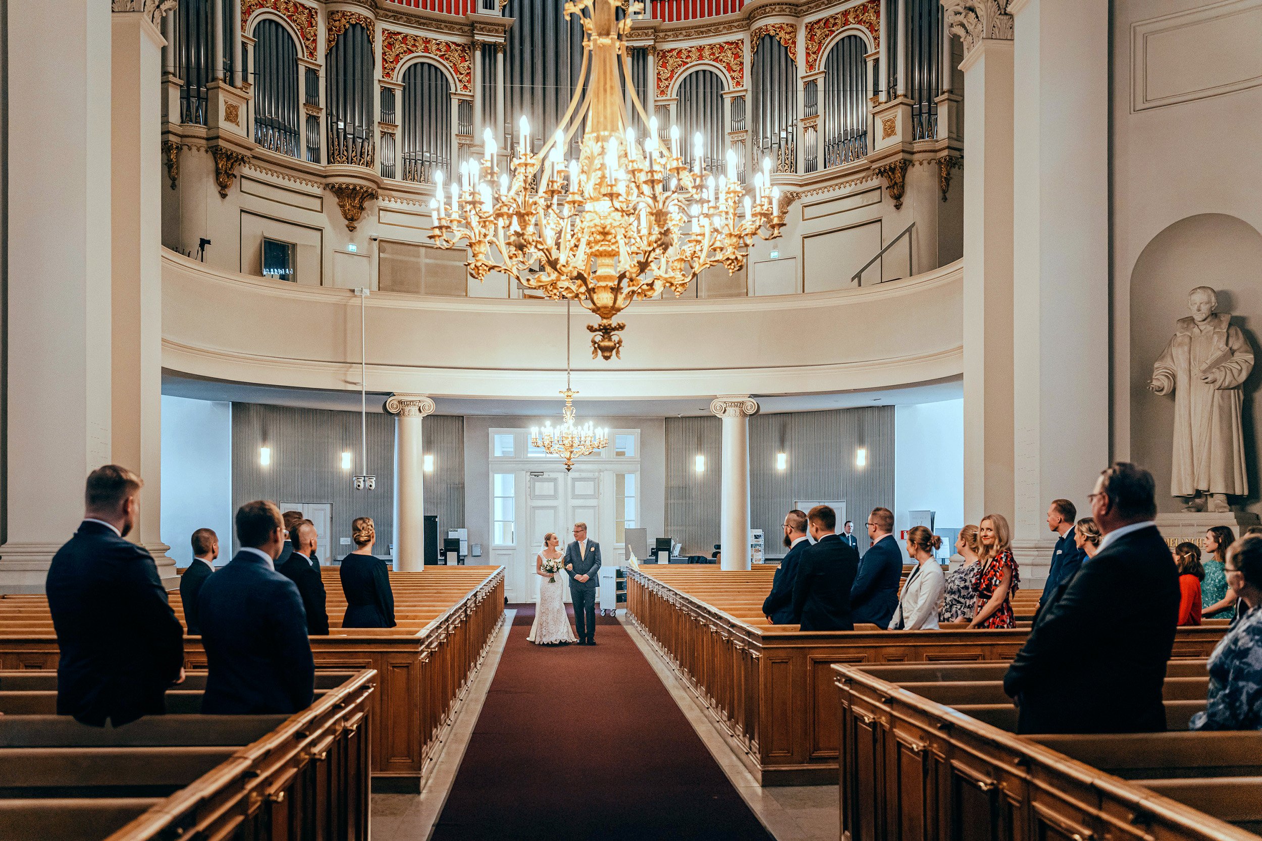 Morsiamen isä saattaa tytärtään Helsingin tuomiokirkon keskuskäytävää pitkin. Hääkuvaus Helsinki - Hyvän mielen hääkuvaaja Sami Turunen.