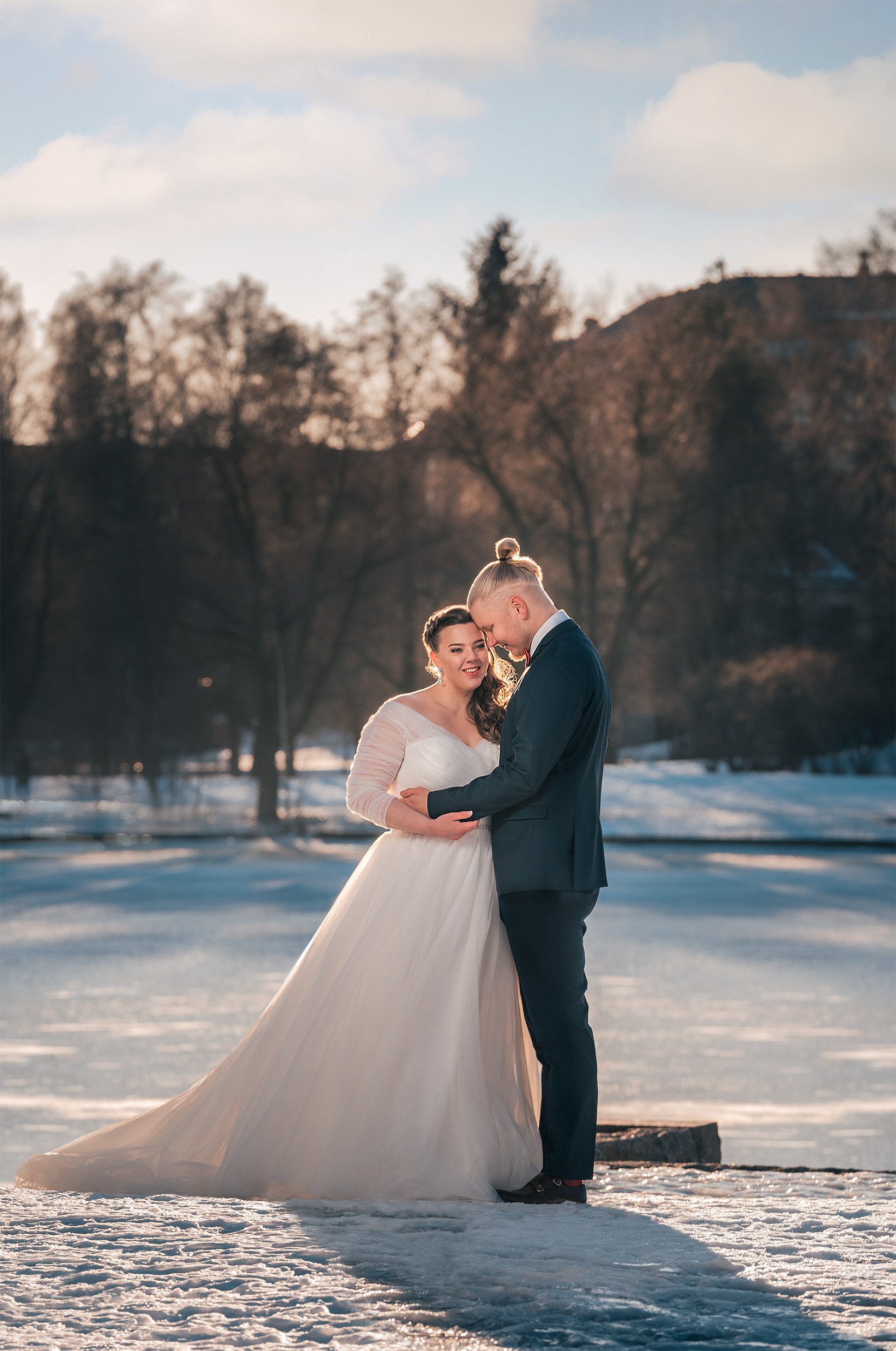 Hääpari hymyilee kuohuvan Vanhankaupunginkosken rannalla talvimaisemissa. Hääkuvaus Helsinki - Hyvän mielen hääkuvaaja Sami Turunen.