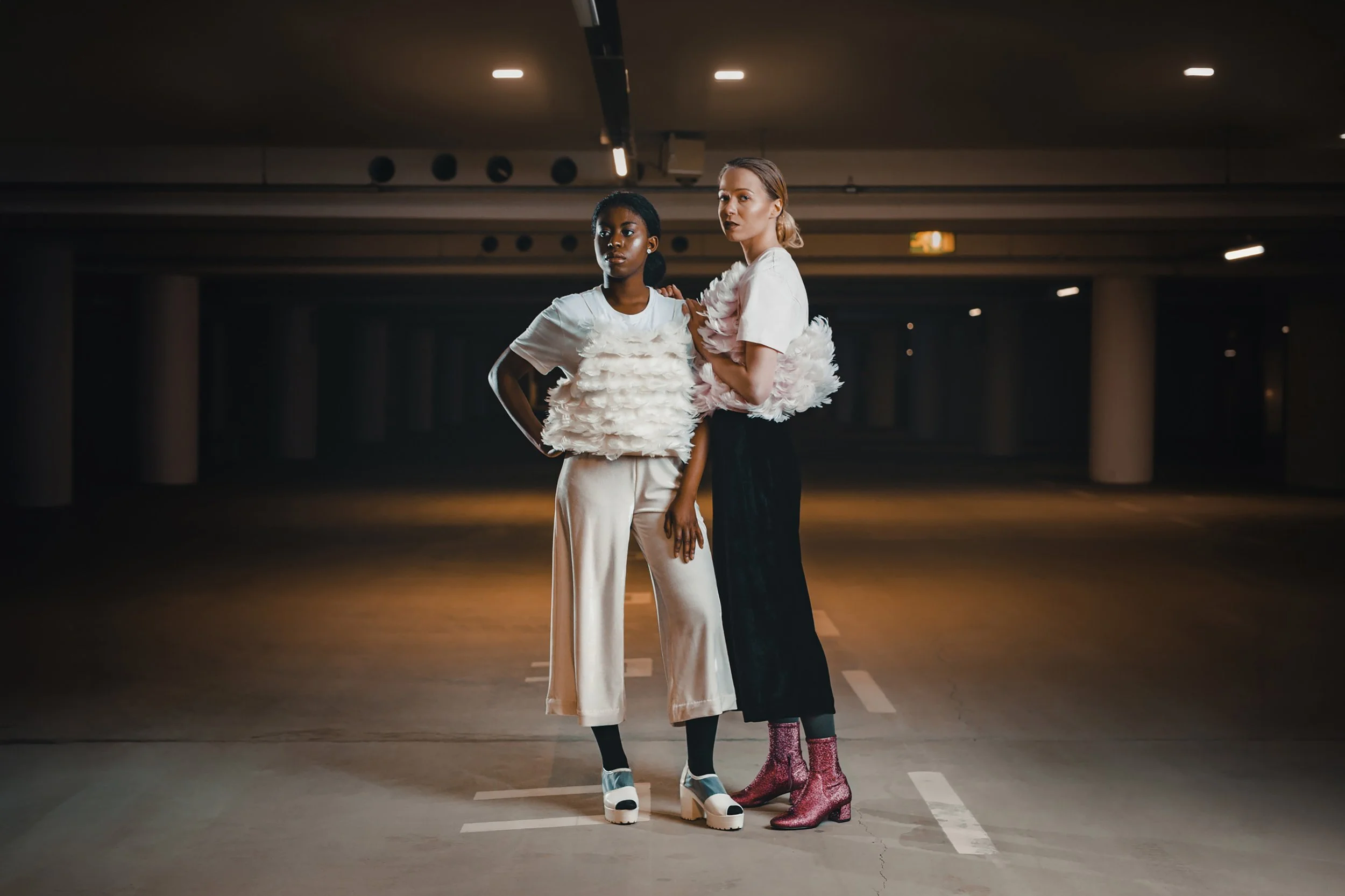 Kirsi Mutsiphule ja Maiju Markkanen Anni Ruuthin Swan Queen Top -asuissa Ruoholahden parkkihallissa. Muotokuvaus Helsinki – hyvän mielen valokuvaaja Sami Turunen.