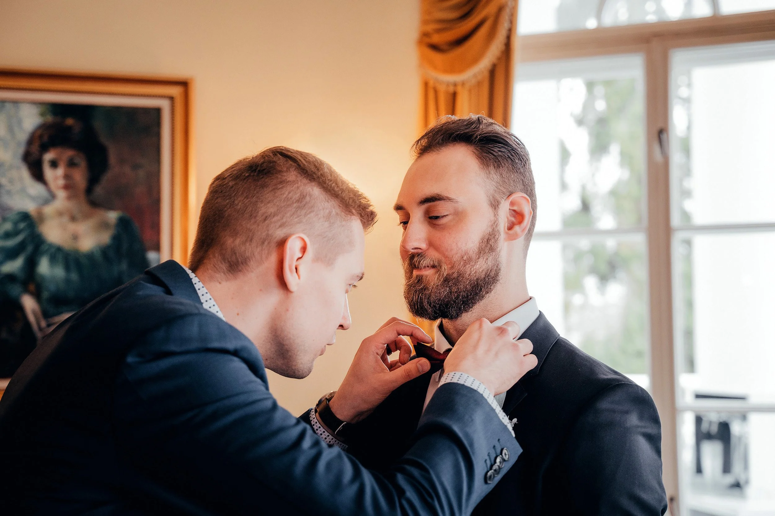 Bestman korjaa rusettia Haikon kartanon juhlasalongissa. Hääkuvaus Porvoo – hyvän mielen valokuvaaja Sami Turunen.