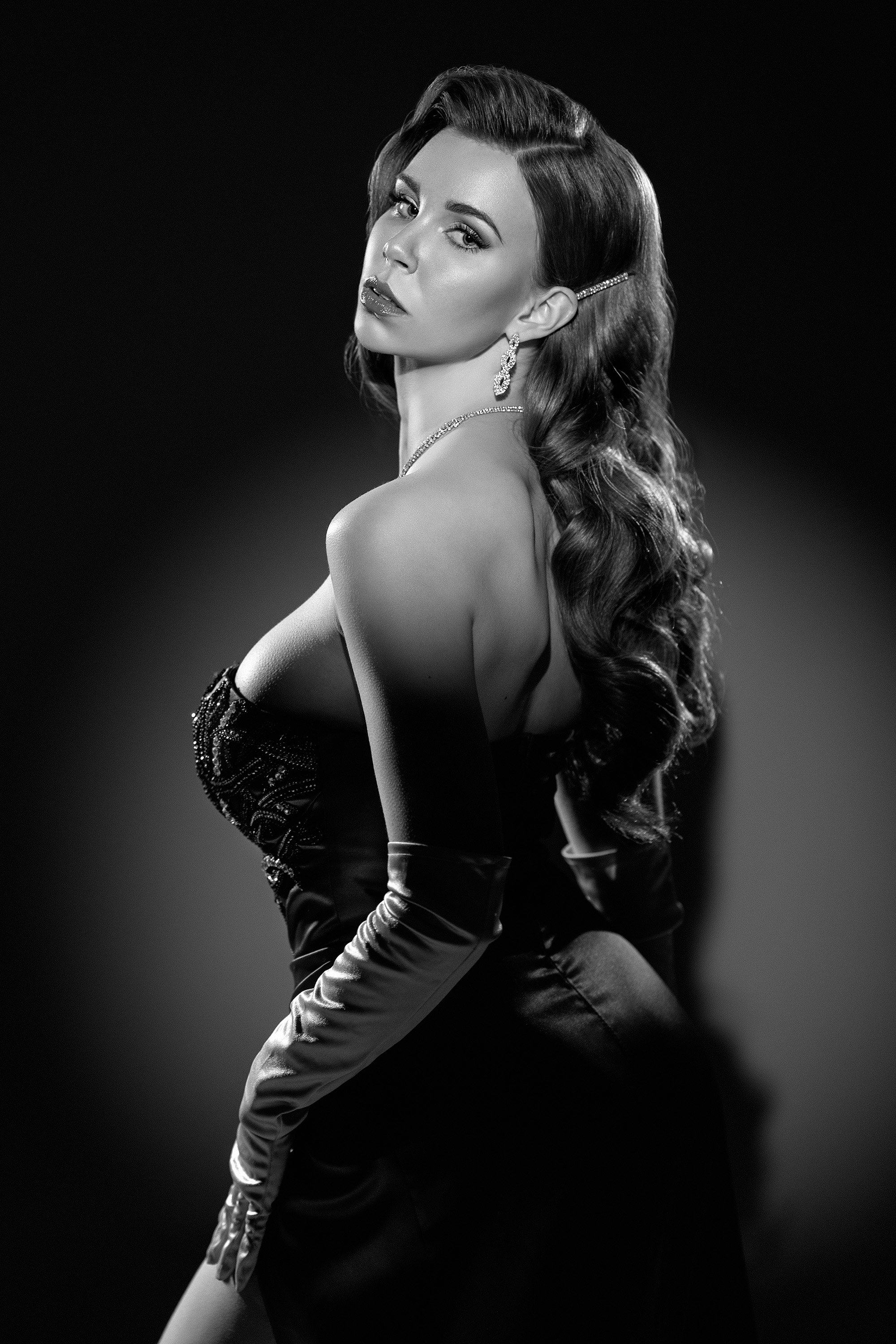 Jenni Pirhonen mustavalkoisessa film noir -tyylisessä femme fatale -muotokuvassa studiossa. Meikki ja hiukset: Eveliina Reunanen, puku: Dila Dress. Muotokuvaus Helsinki – hyvän mielen valokuvaaja Sami Turunen.