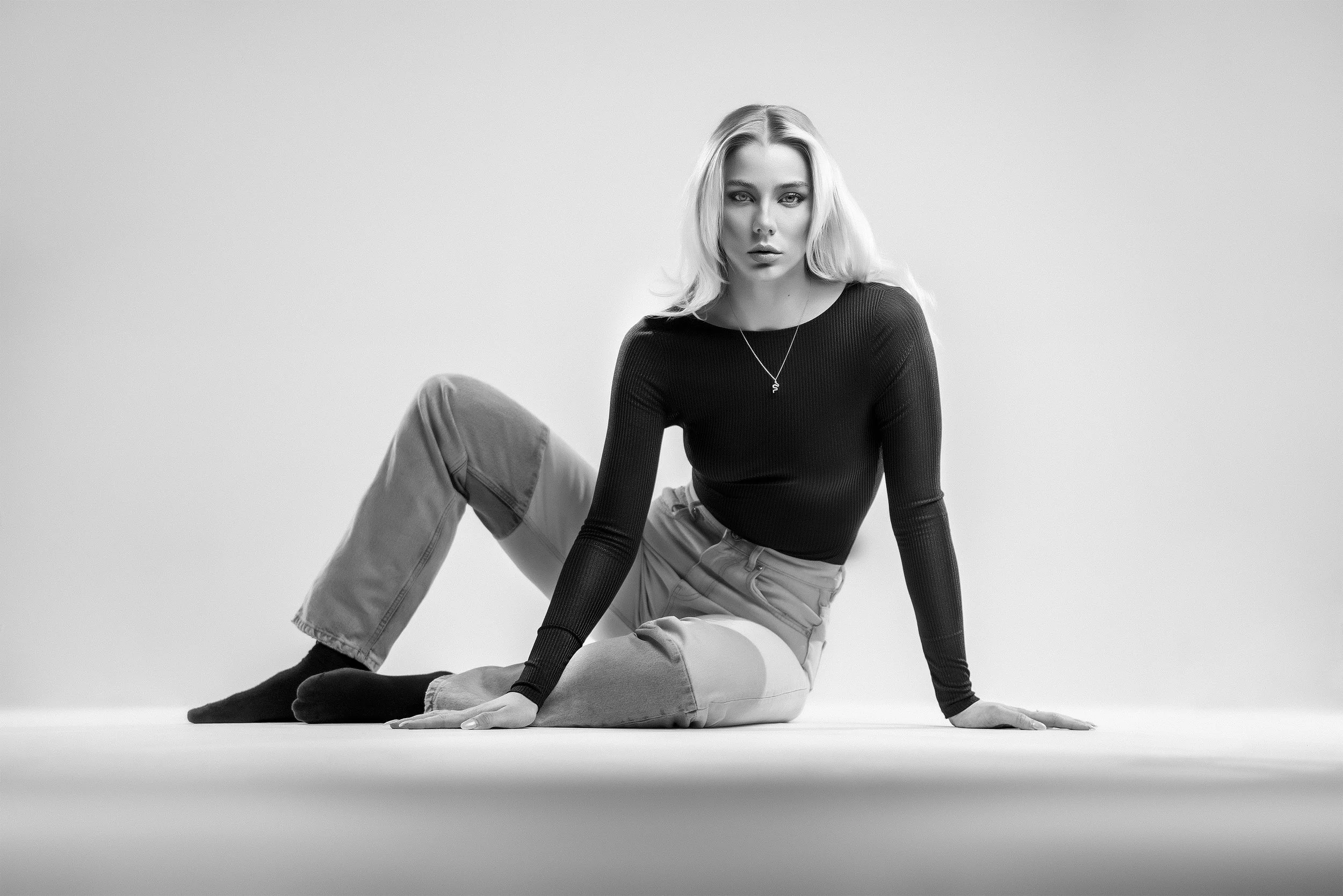 Emma Schrey istuu lattialla mustavalkoisessa editorial-muotokuvassa. Muotokuvaus Helsinki – hyvän mielen valokuvaaja Sami Turunen.