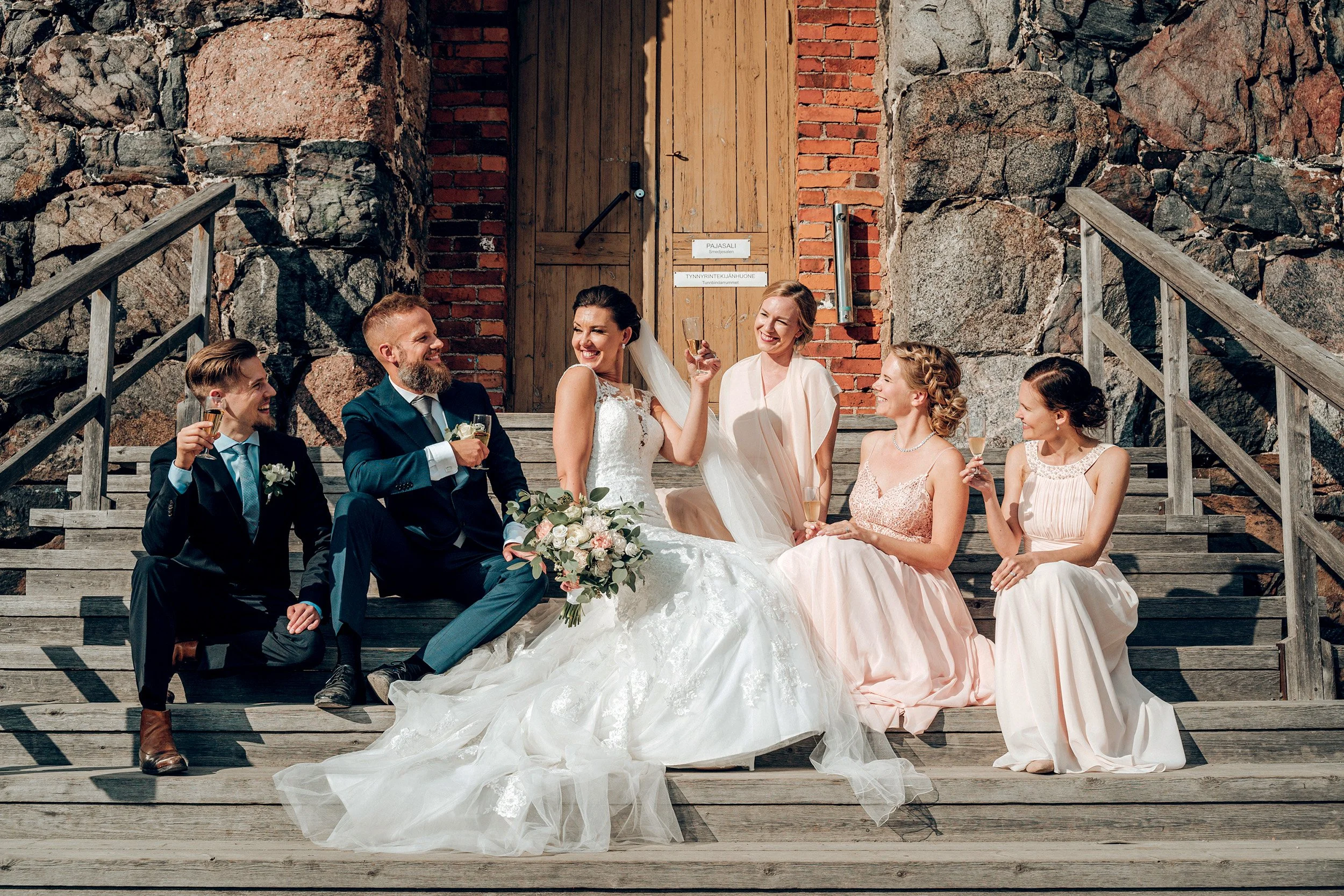 Hääpari, bestmanit ja kaasot Pirunkirkon portailla Suomenlinnassa. Hääkuvaus Helsinki - Hyvän mielen hääkuvaaja Sami Turunen.