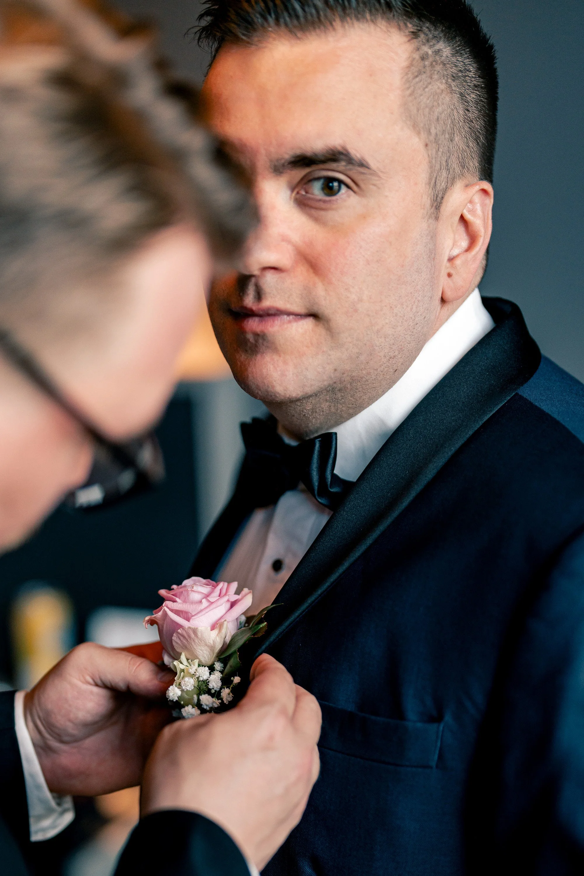 Bestman kiinnittää sulhasen viehettä puvun liepeeseen Hotel NH Collectionissa Helsingissä. Hääkuvaus Helsinki - Hyvän mielen hääkuvaaja Sami Turunen.