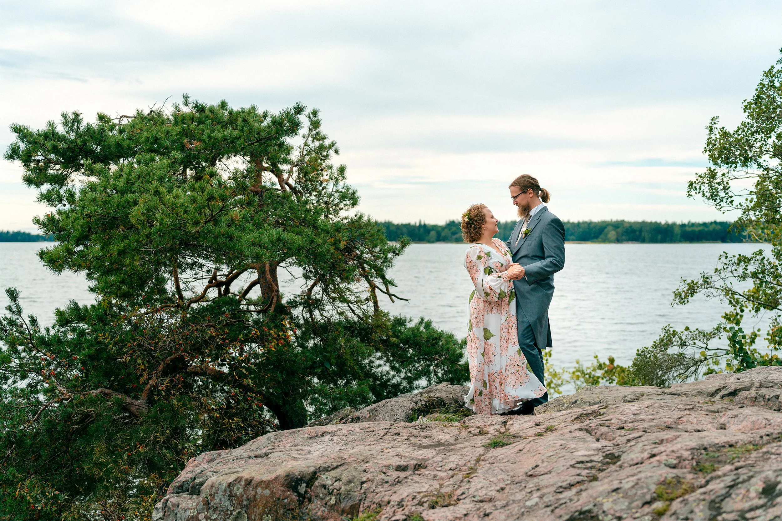 Hääpari poseeraa kesäisissä merimaisemissa Soutustadionin kalliolla Helsingissä. Hääkuvaus Helsinki - Hyvän mielen hääkuvaaja Sami Turunen.