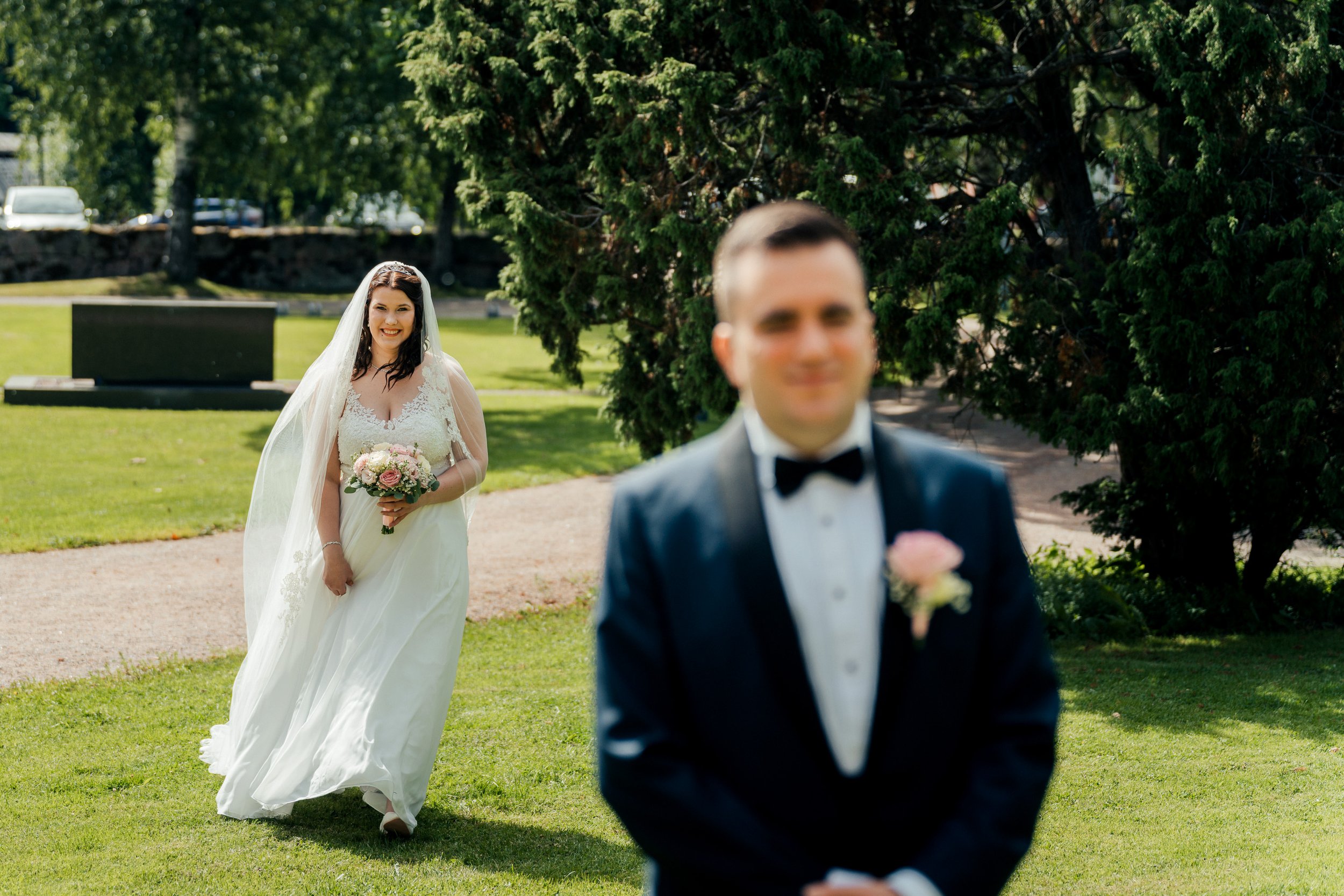 Morsian saapuu paikalle first look -kuvassa Pyhän Laurin kirkon puistomaisissa maisemissa Vantaalla. Hääkuvaus Vantaa - Hyvän mielen hääkuvaaja Sami Turunen.