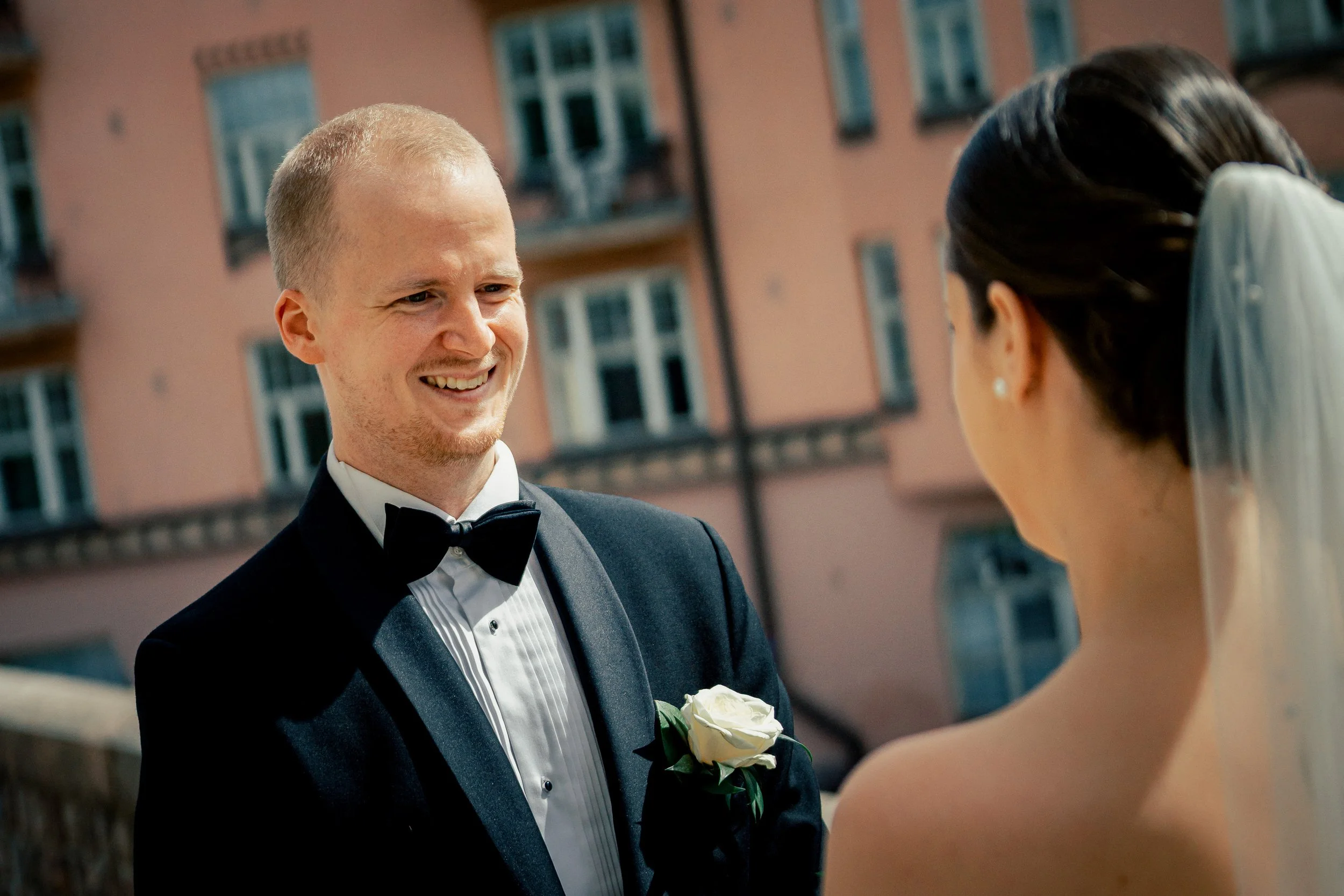 Sulhanen kääntyy ja katsoo ihastuksissaan morsianta first look -kuvassa Kallion kirkon edessä. Hääkuvaus Helsinki – hyvän mielen valokuvaaja Sami Turunen.
