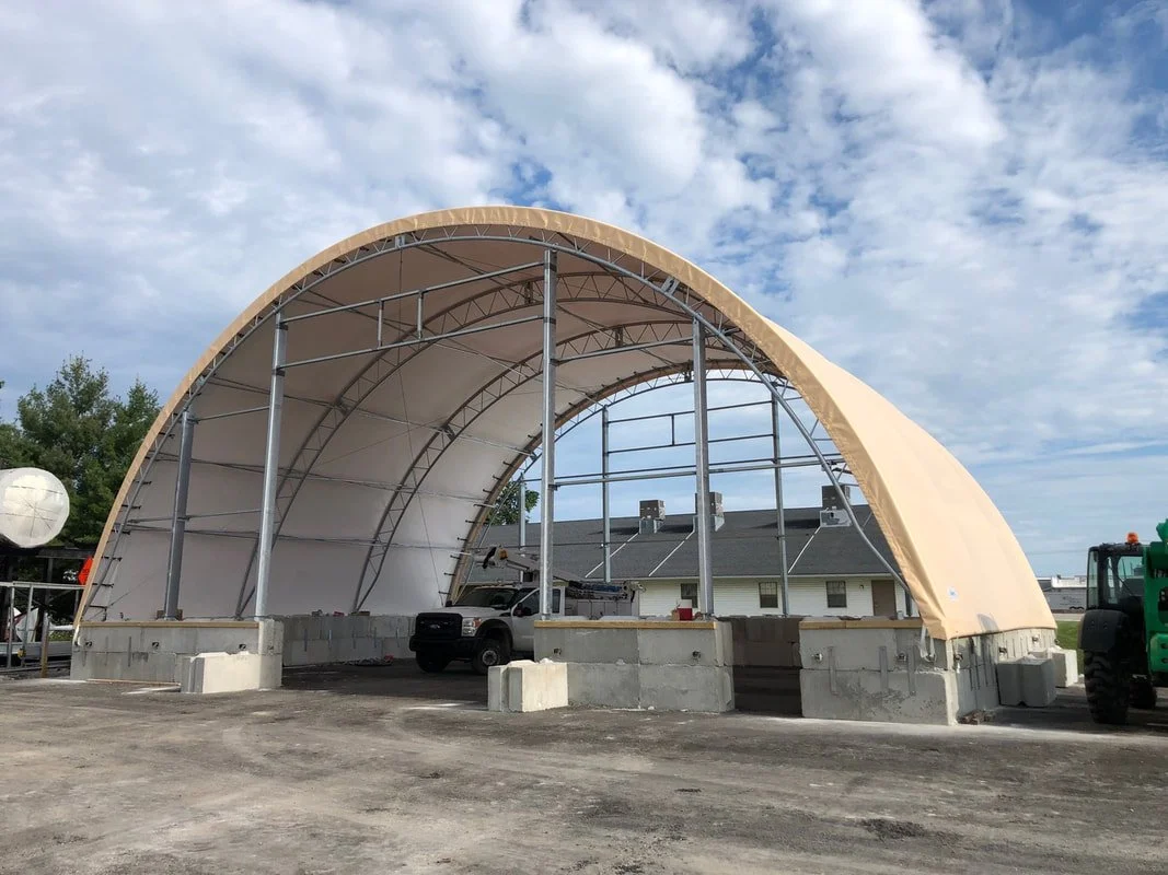 Fabric structure during construction phase, demonstrating sequencing of steel erection, anchorage, and membrane installation for controlled structural performance.