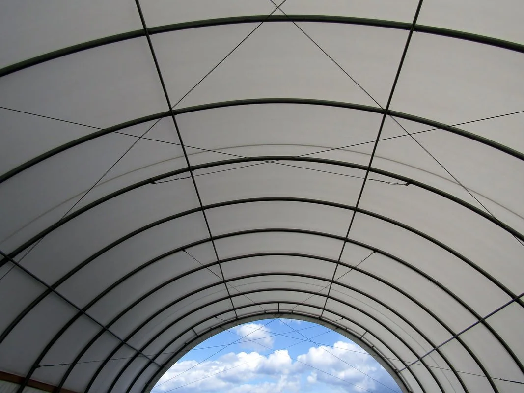 Interior view of tensioned membrane showing uniform curvature and pre-stressed fabric behavior essential for resisting wind uplift and maintaining structural stability.
