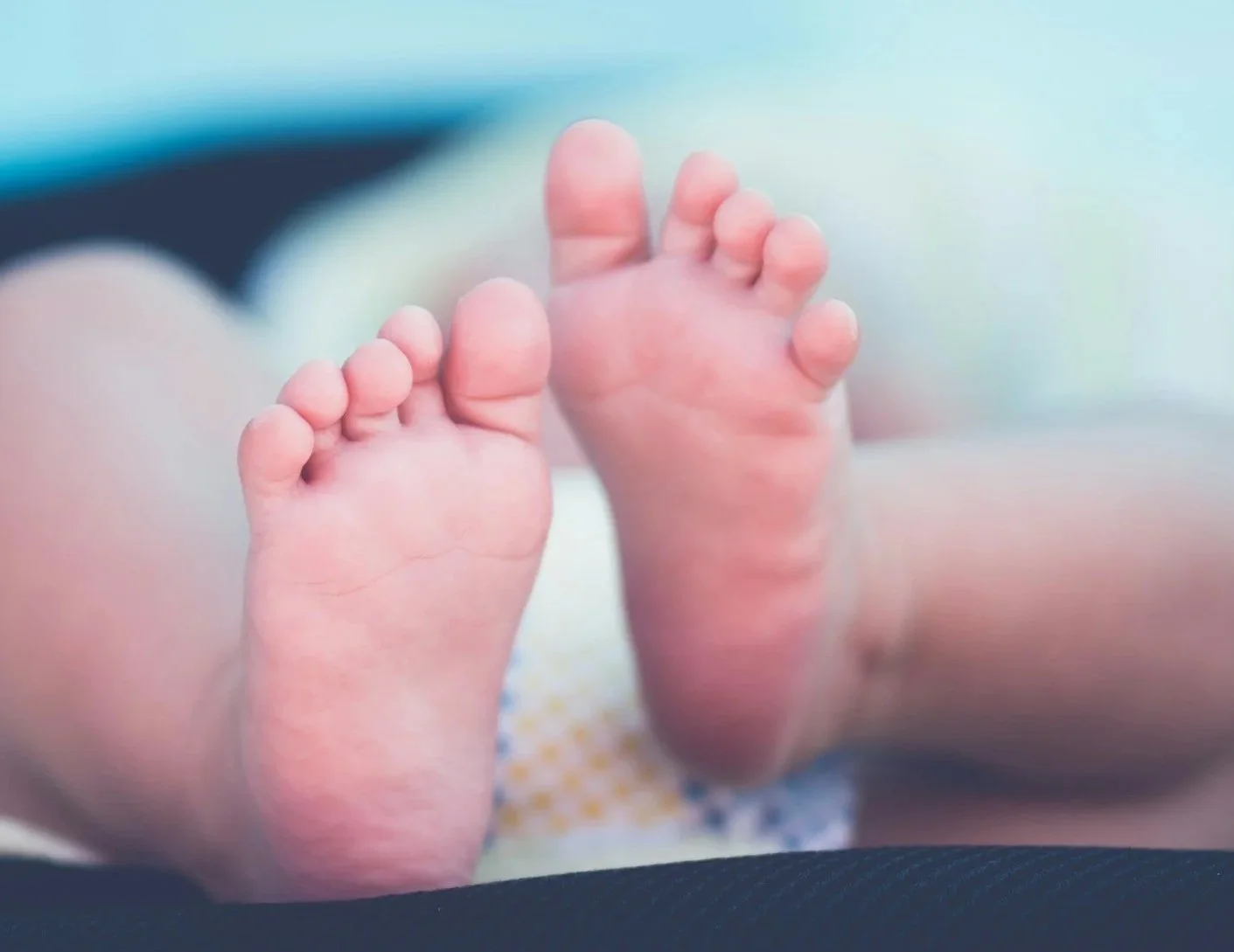 Mother caring for her newborn while experiencing common signs of postpartum anxiety, including excessive worry, racing thoughts, and difficulty relaxing
