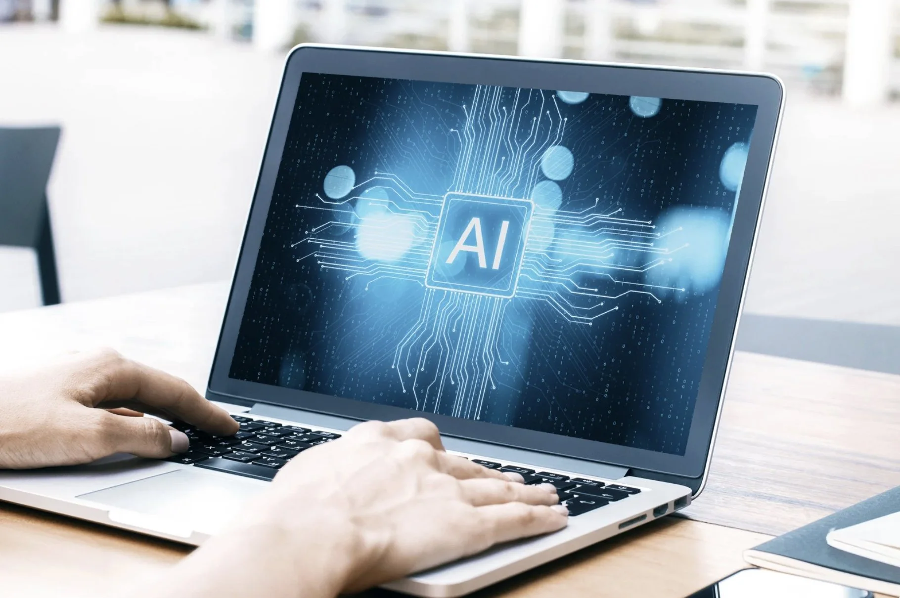 Pessoa usando laptop com tela exibindo gráfico digital e a sigla AI em destaque.