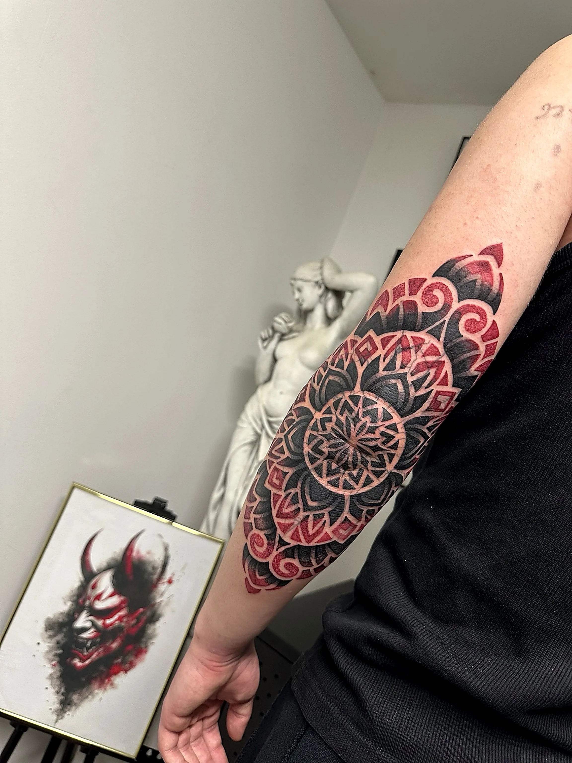 Tatuaj geometric cu accente de roșu, compoziție personalizată.