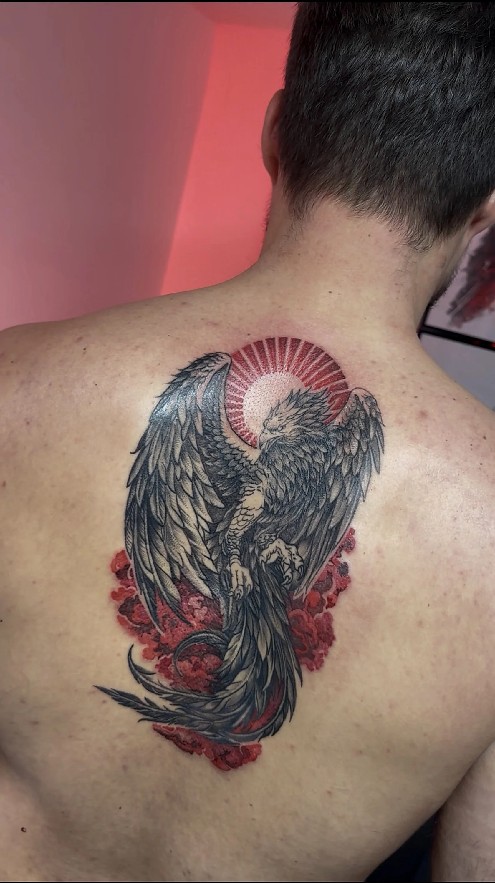 Tatuaj graphic cu accente de roșu, compoziție personalizată.