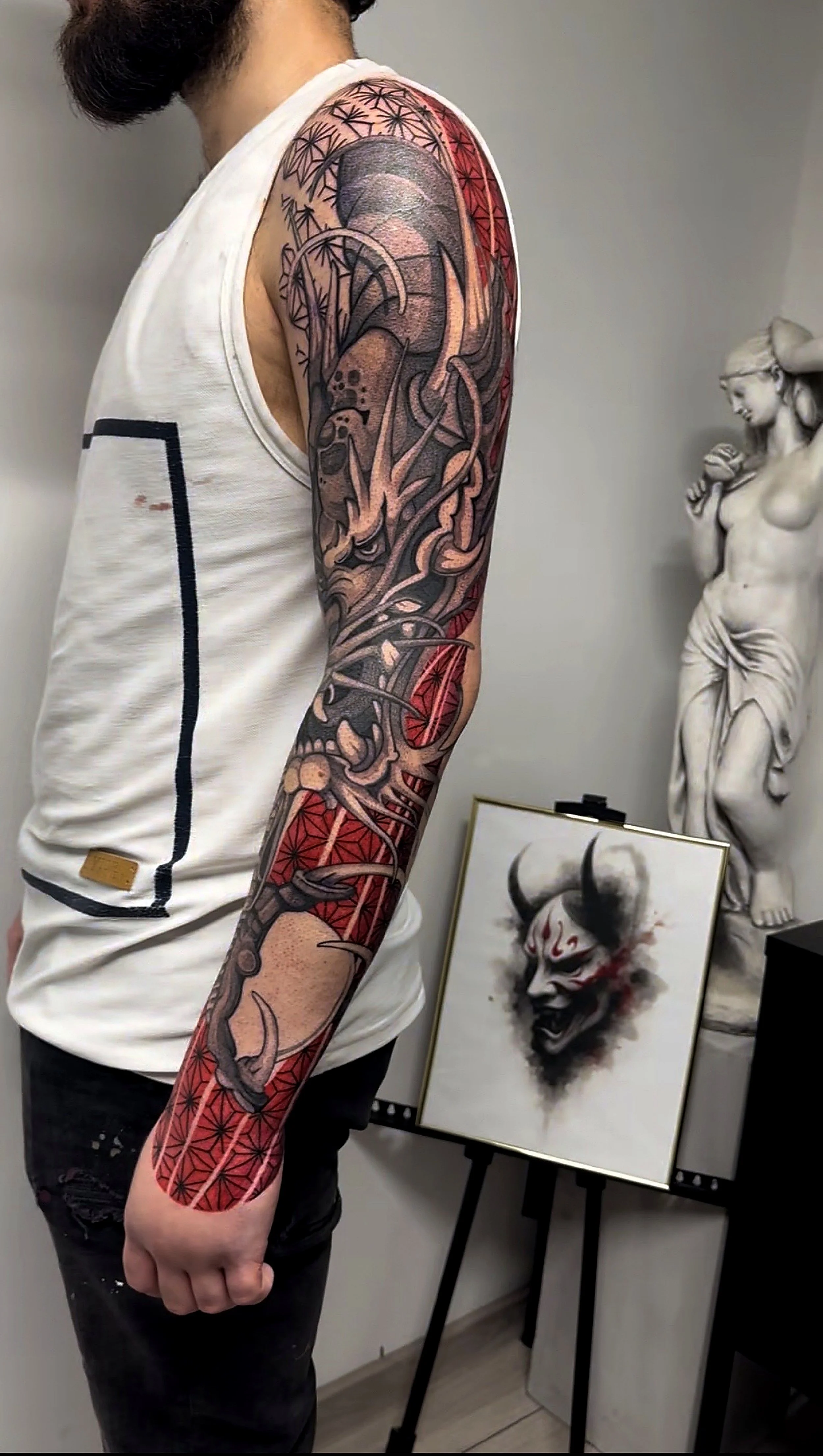 Tatuaj graphic-abstract cu accente de roșu, compoziție personalizată.