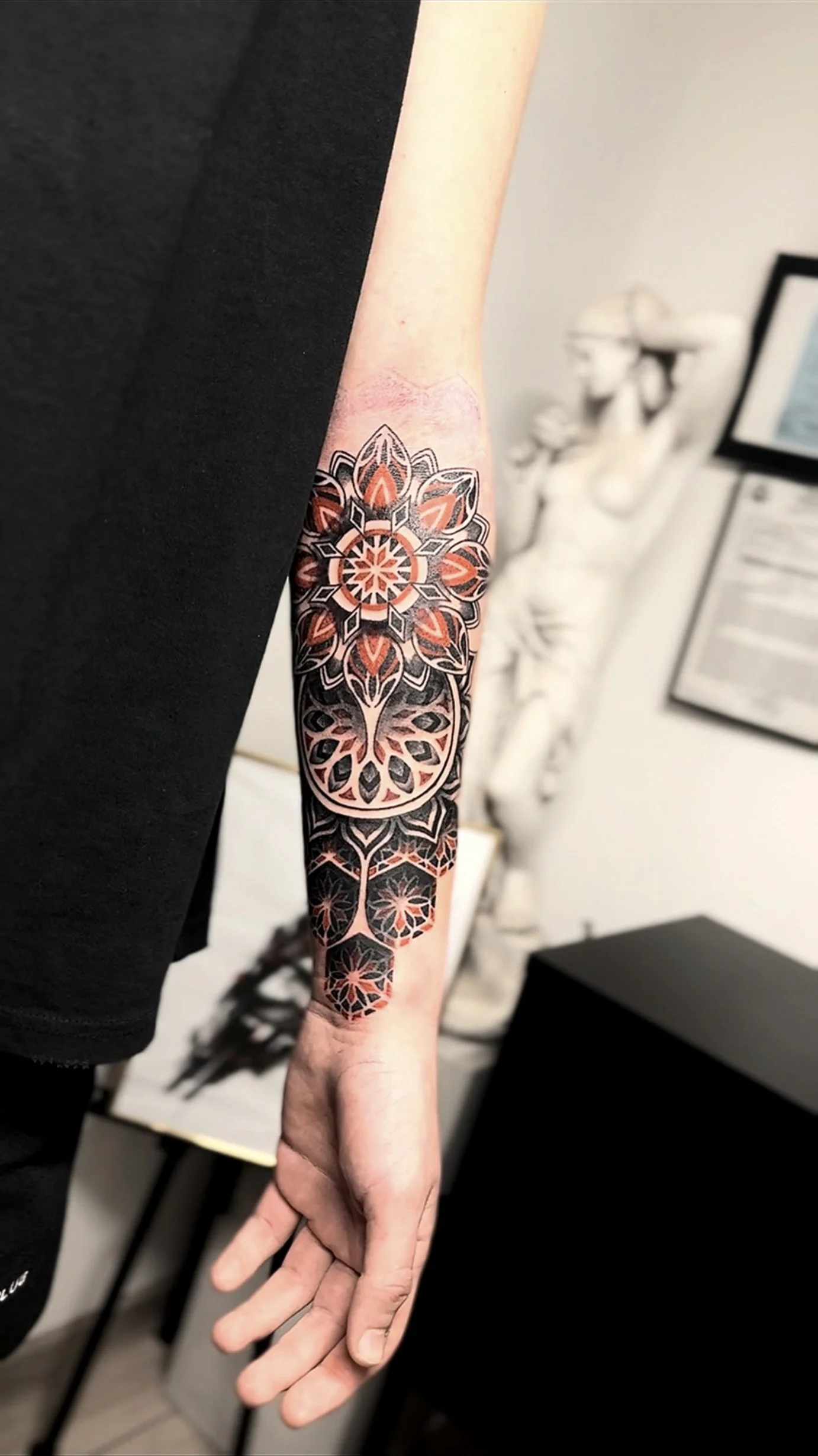 Tatuaj geometric cu accente de roșu, compoziție personalizată.
