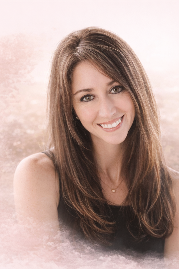 Smiling woman with long brown hair and a black top, outdoor background with soft lighting.