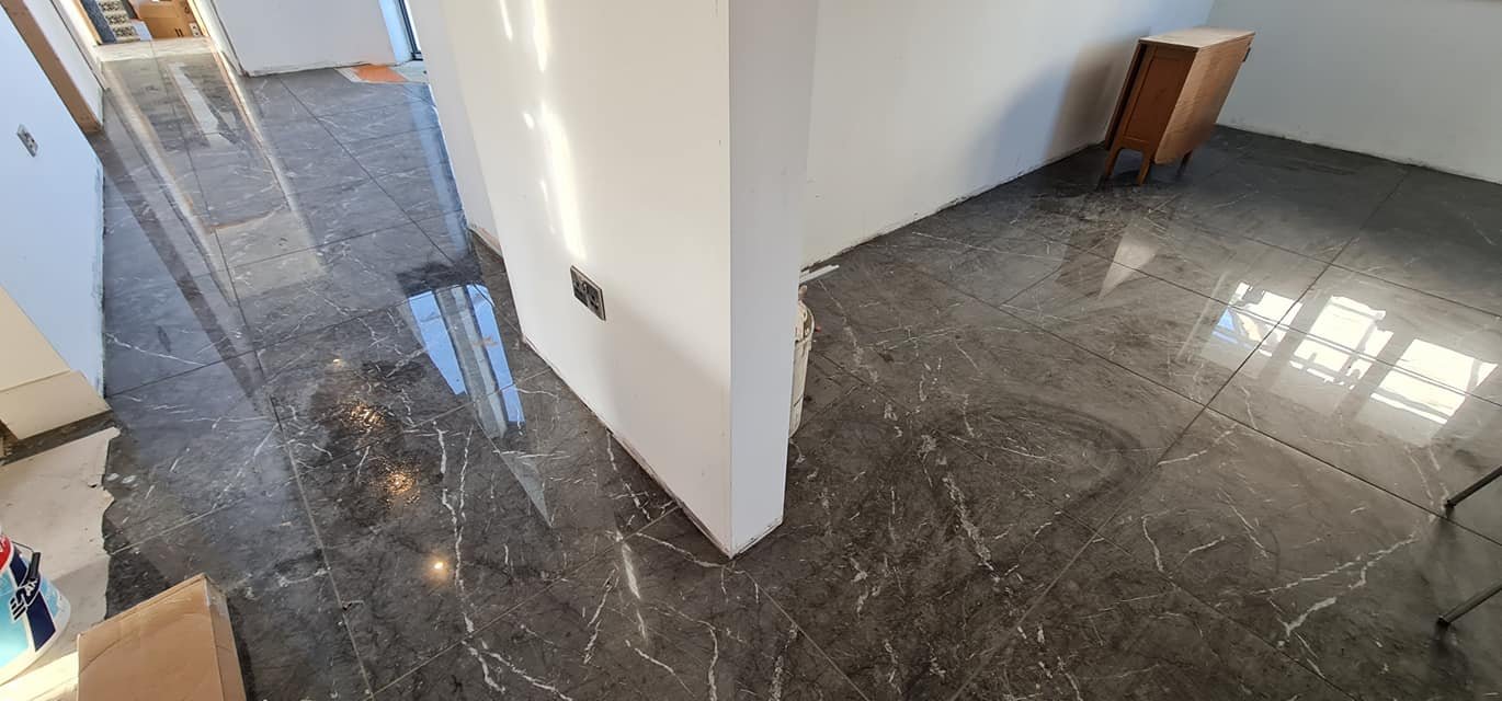 Royal brown marble floor in a room with a small wooden cabinet and a curved wall.
