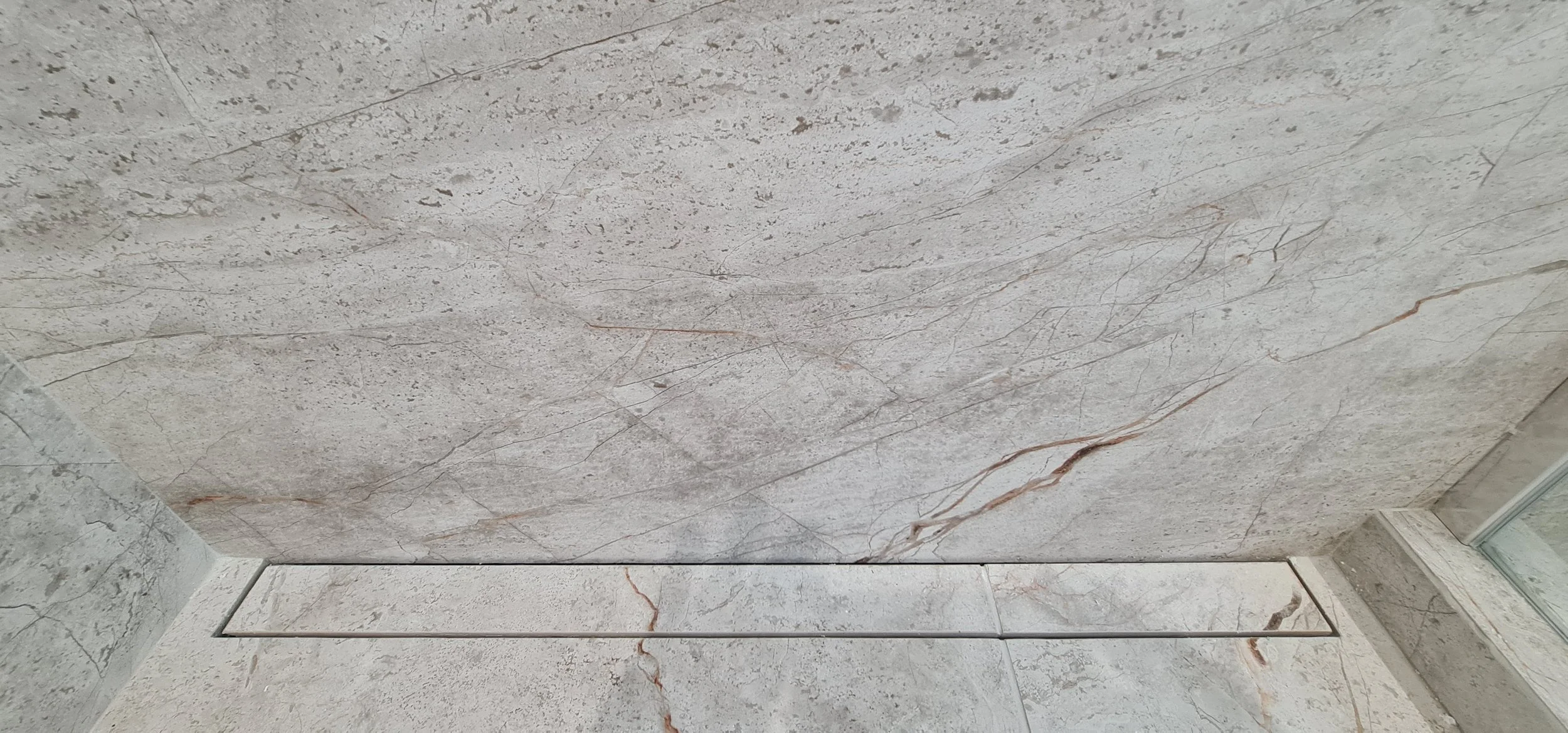 Close-up of a marble or granite wall with natural veining and texture.