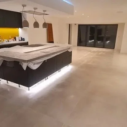 Unfinished modern kitchen with an island, pendant lights, and large sliding glass doors leading to an outdoor space.