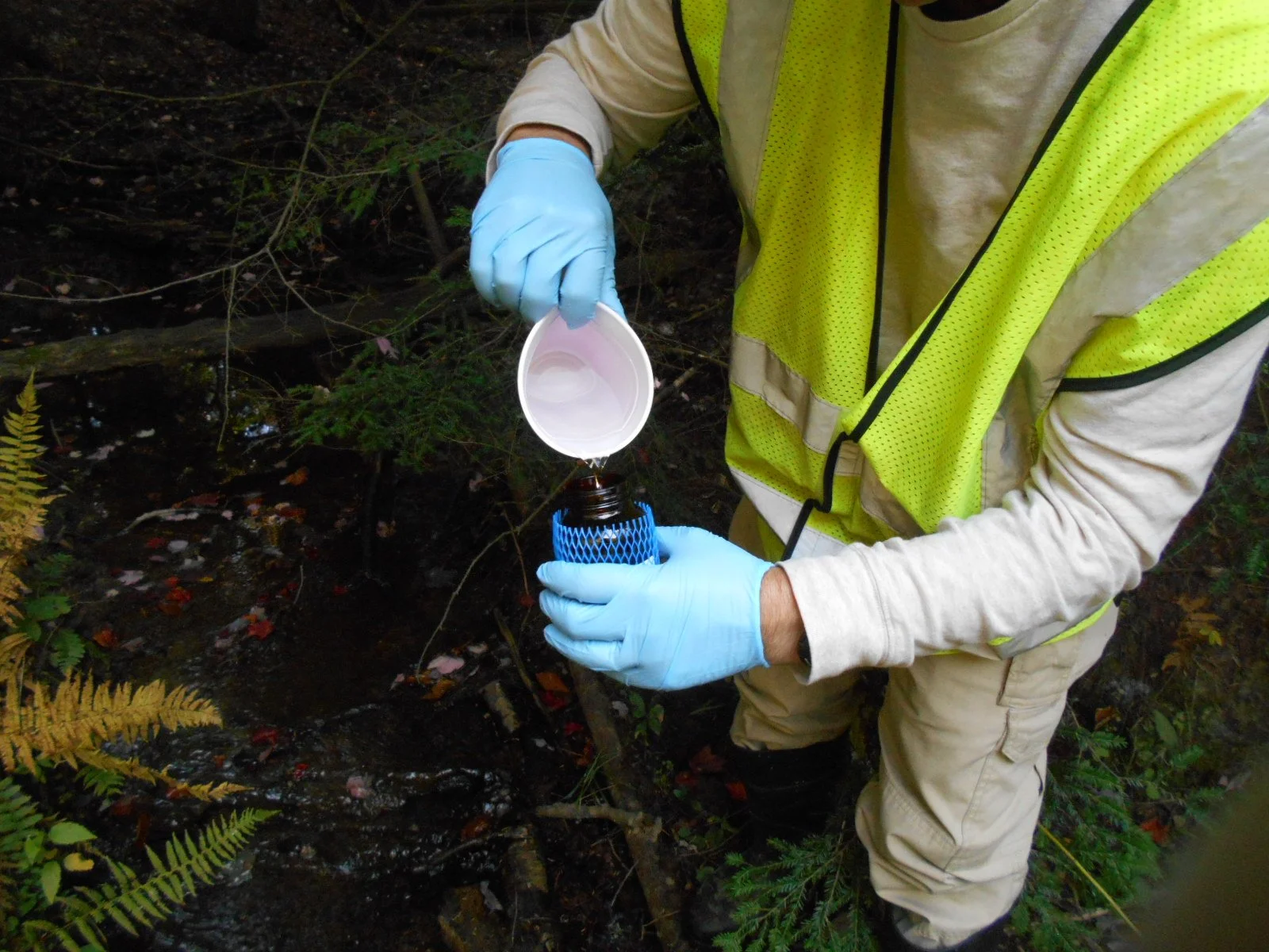 Collecting a water sample during a Phase II Environmental Site Assessment (ESA).