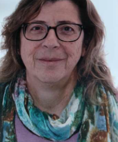 Woman with glasses, shoulder-length brown hair, and a colorful scarf.