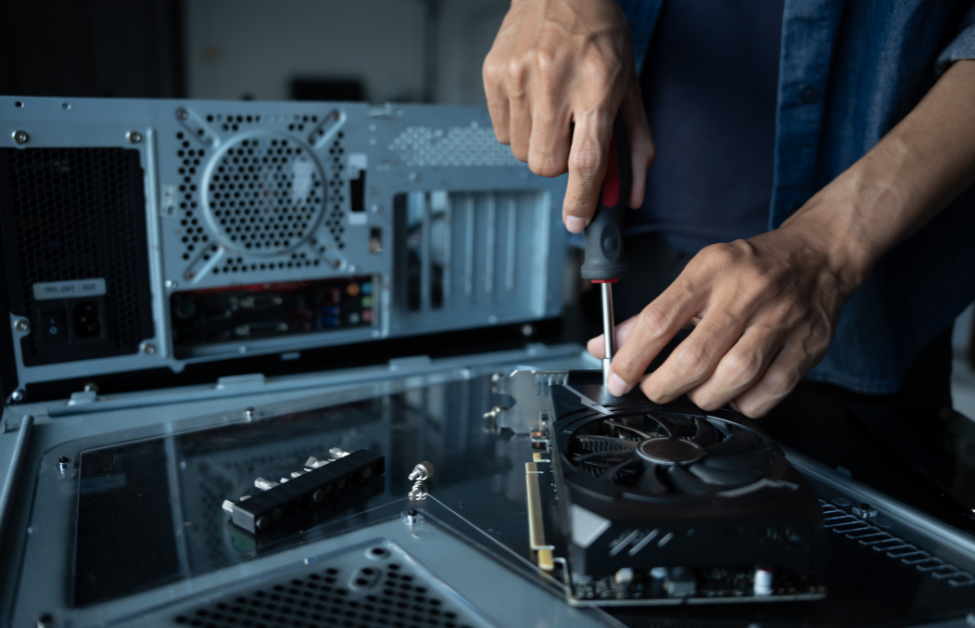 Persona ensamblando una tarjeta gráfica en una computadora de escritorio usando un destornillador