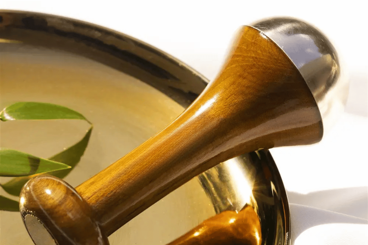 A kansa wand sitting on a bronze plate