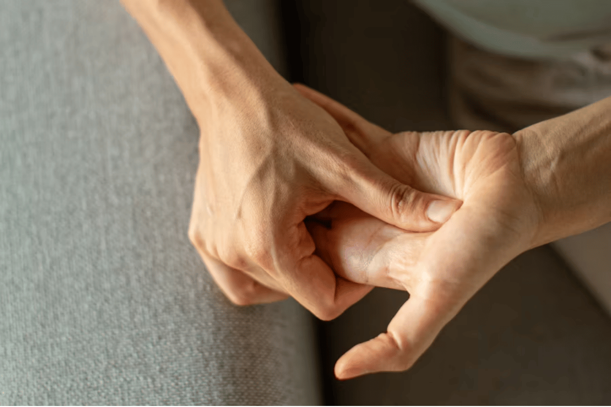 An esthetician doing marma point therapy on a clients hand
