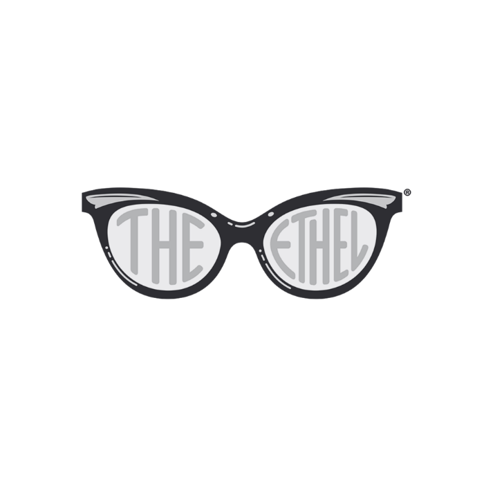 A pair of black sunglasses with the words 'THE' in the left lens and 'EACH' in the right lens, forming the phrase 'THE 'EACH'.