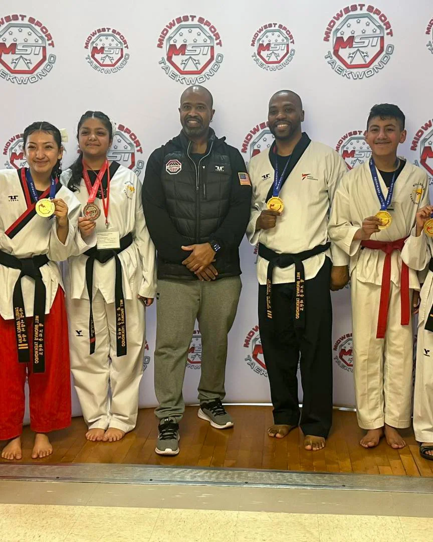  Students stand with Master Will Brown and display their gold medals at a Midwest Sport Taekwondo tournament. 