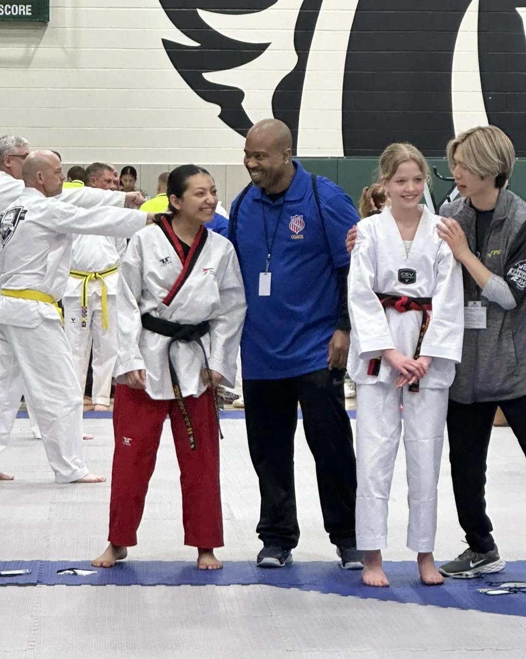 Master Will Brown celebrating with two students after competing at a Taekwondo tournament.