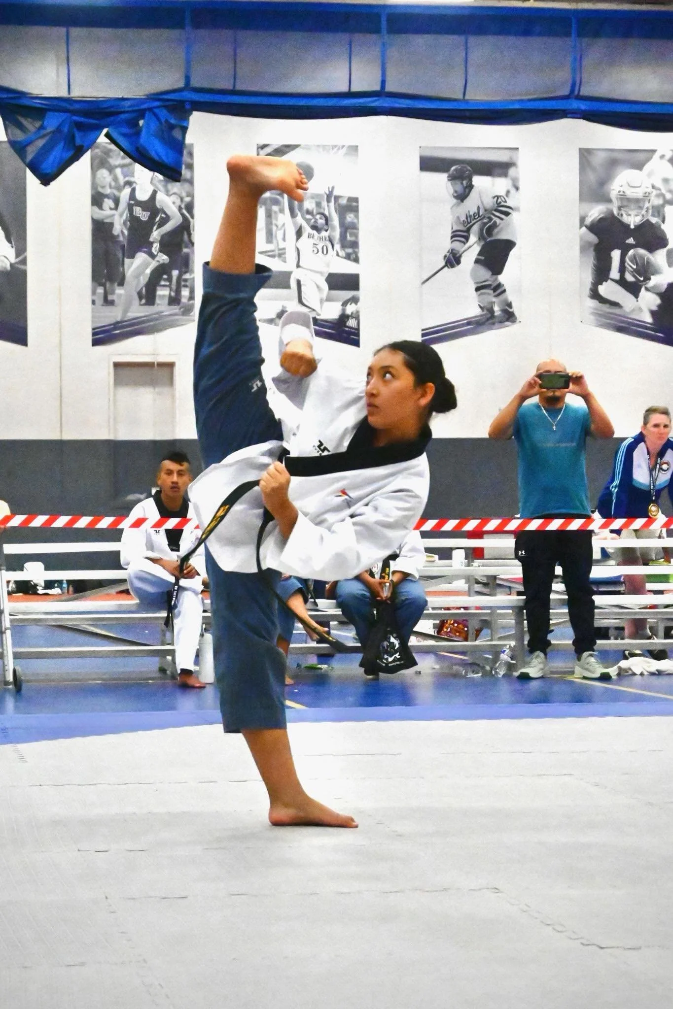 Will Brown's Taekwondo Assistant Instructor Danielle Abarca executing a high kick during competition at a Taekwondo tournament.