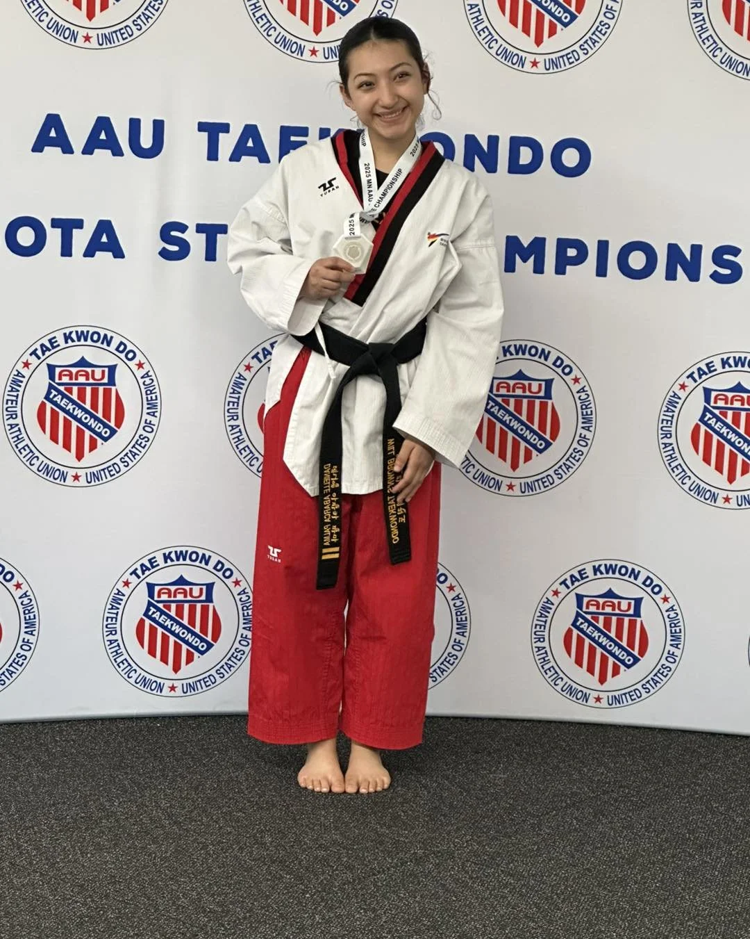 Will Brown's Taekwondo Assistant Instructor Danielle Abarca holding her medal after competing at the AAU Taekwondo Minnesota State Championships.