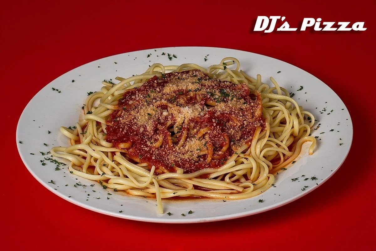 Plate of spaghetti with marinara sauce and grated cheese, garnished with herbs on a white dish against a red background with the text 'DJ's Pizza' in the top right corner.