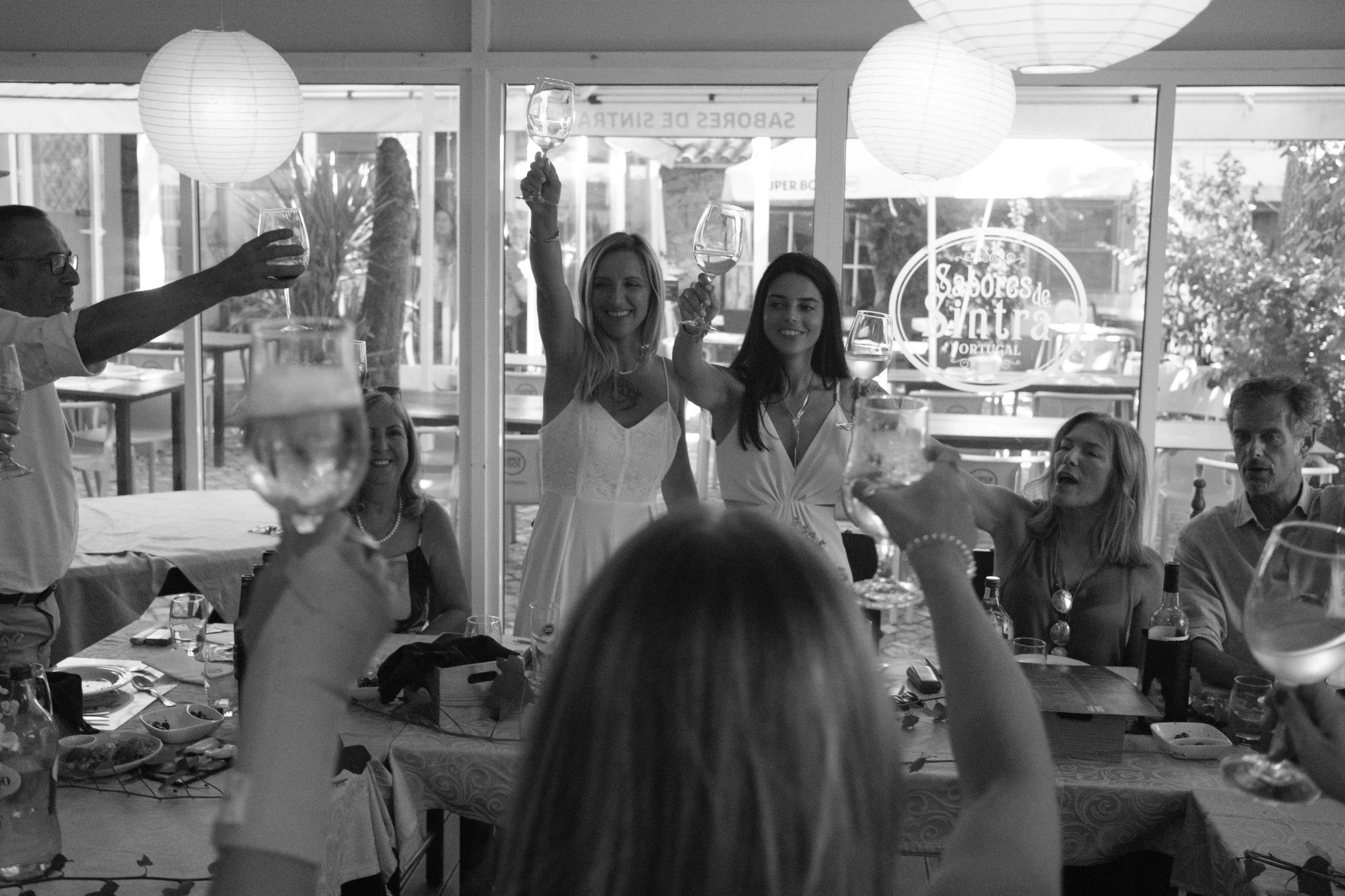 Sofia and Leonor raising a toast with family and friends during their wedding celebration in Sintra.